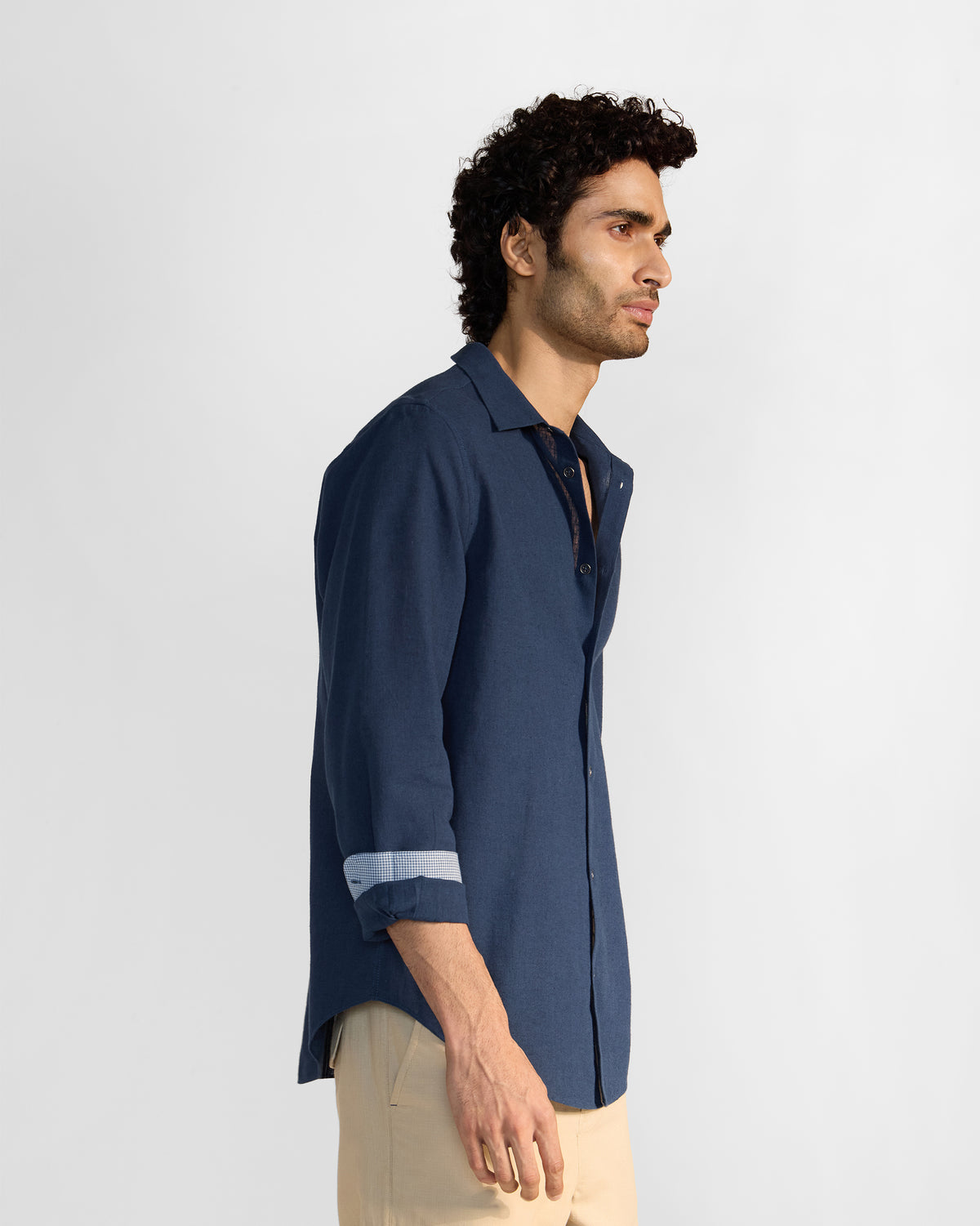 Side view of a navy Rewa shirt with rolled sleeves.