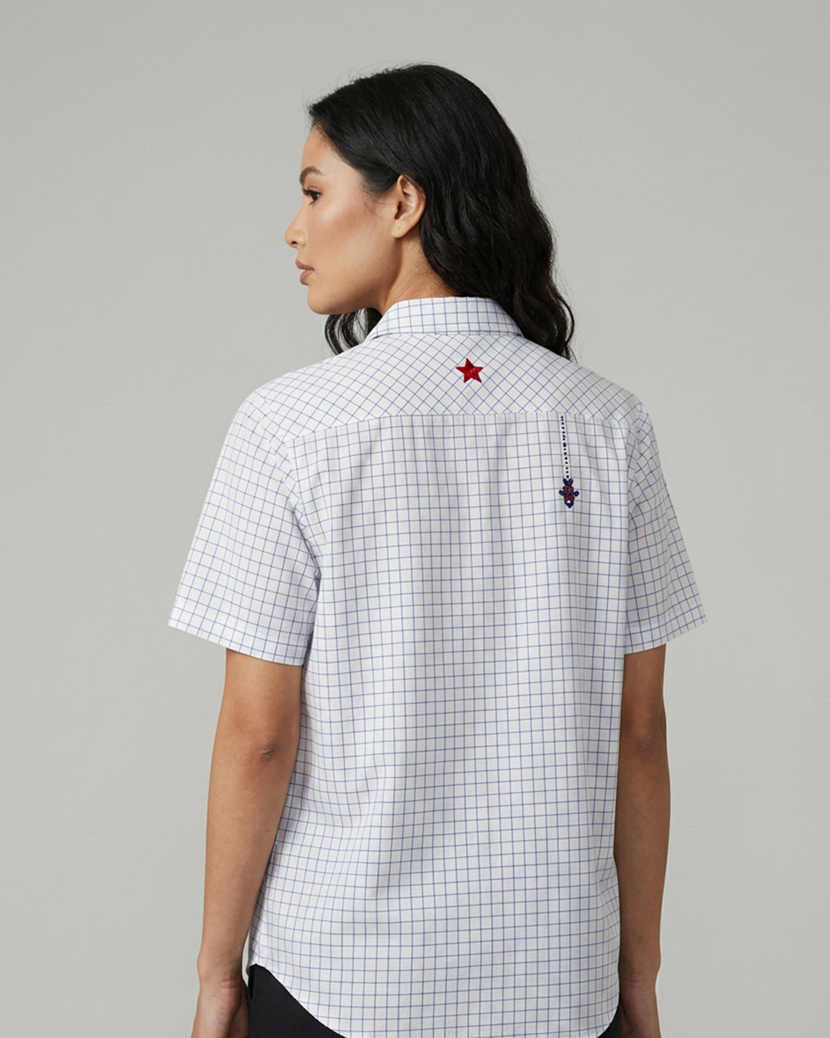 Back of a navy and white Parikrama shirt with a red star and bias-cut yoke.