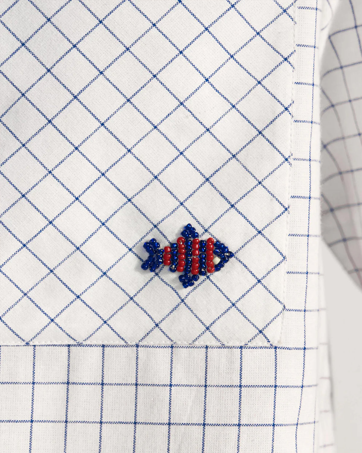 Close-up of a Parikrama shirt pocket with red and blue fish beadwork.