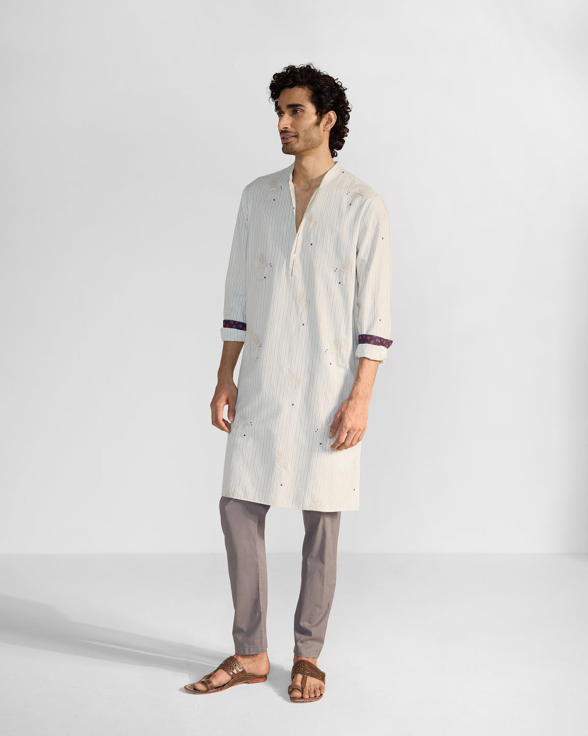 Person wearing an ivory Astral kurta with dragonfly embroidery.