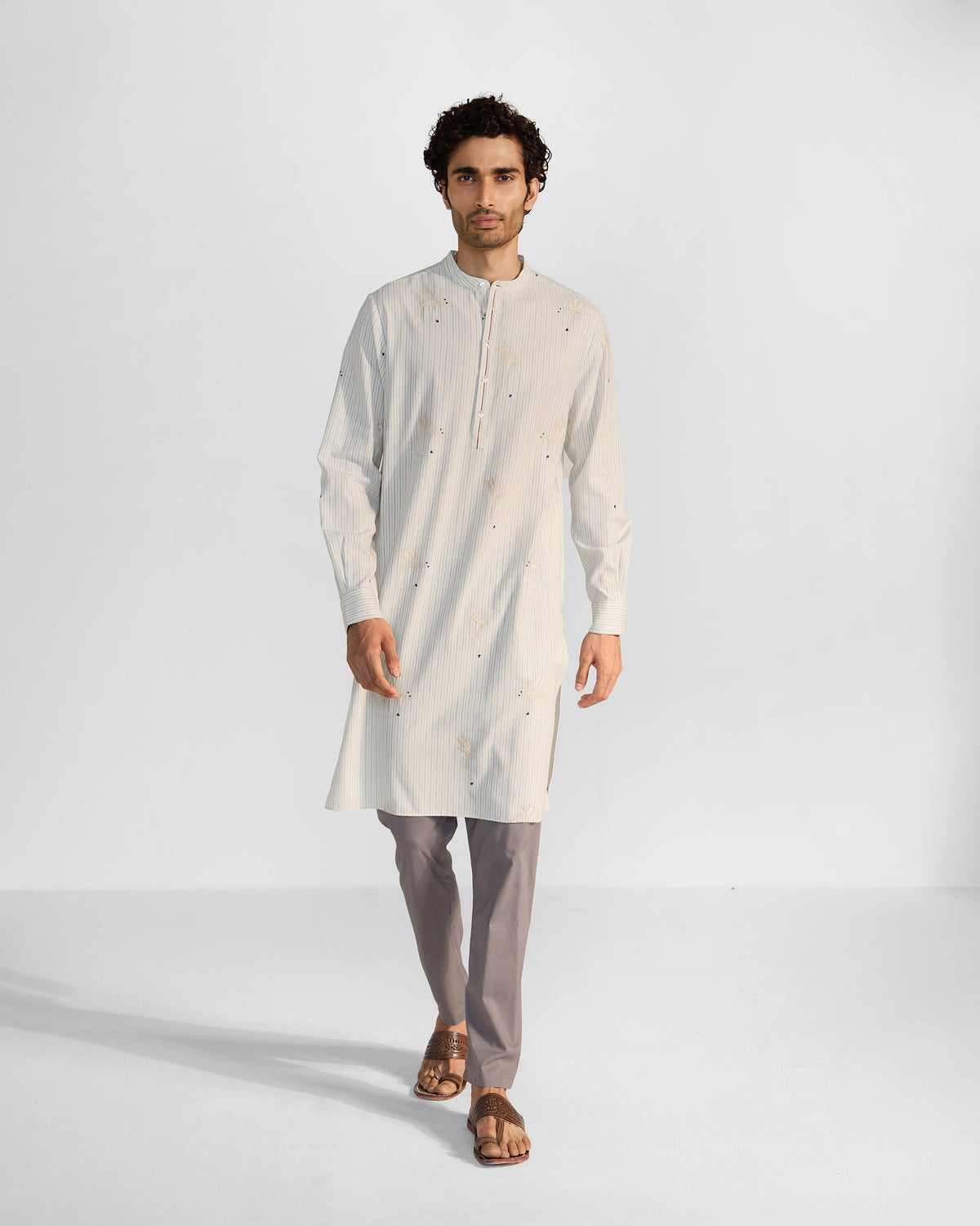 Person wearing an ivory and navy Astral kurta with dragonfly embroidery.