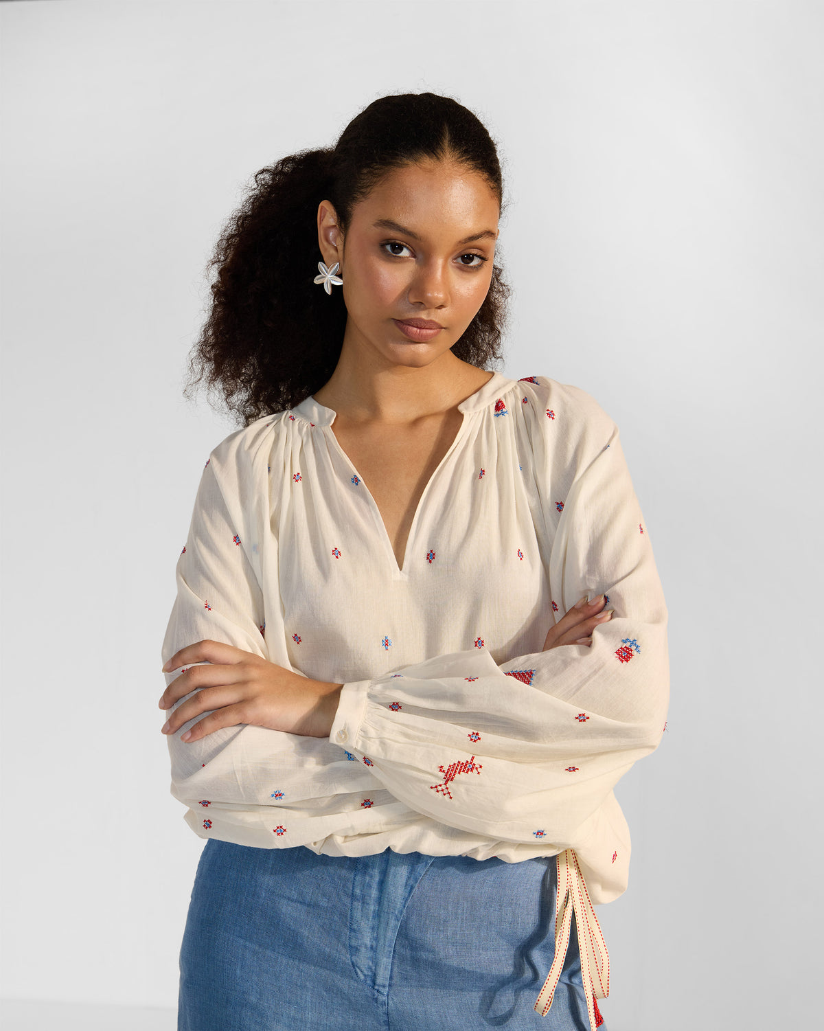 Person wearing an ivory Tahi top with a V-neck and striped drawstring.
