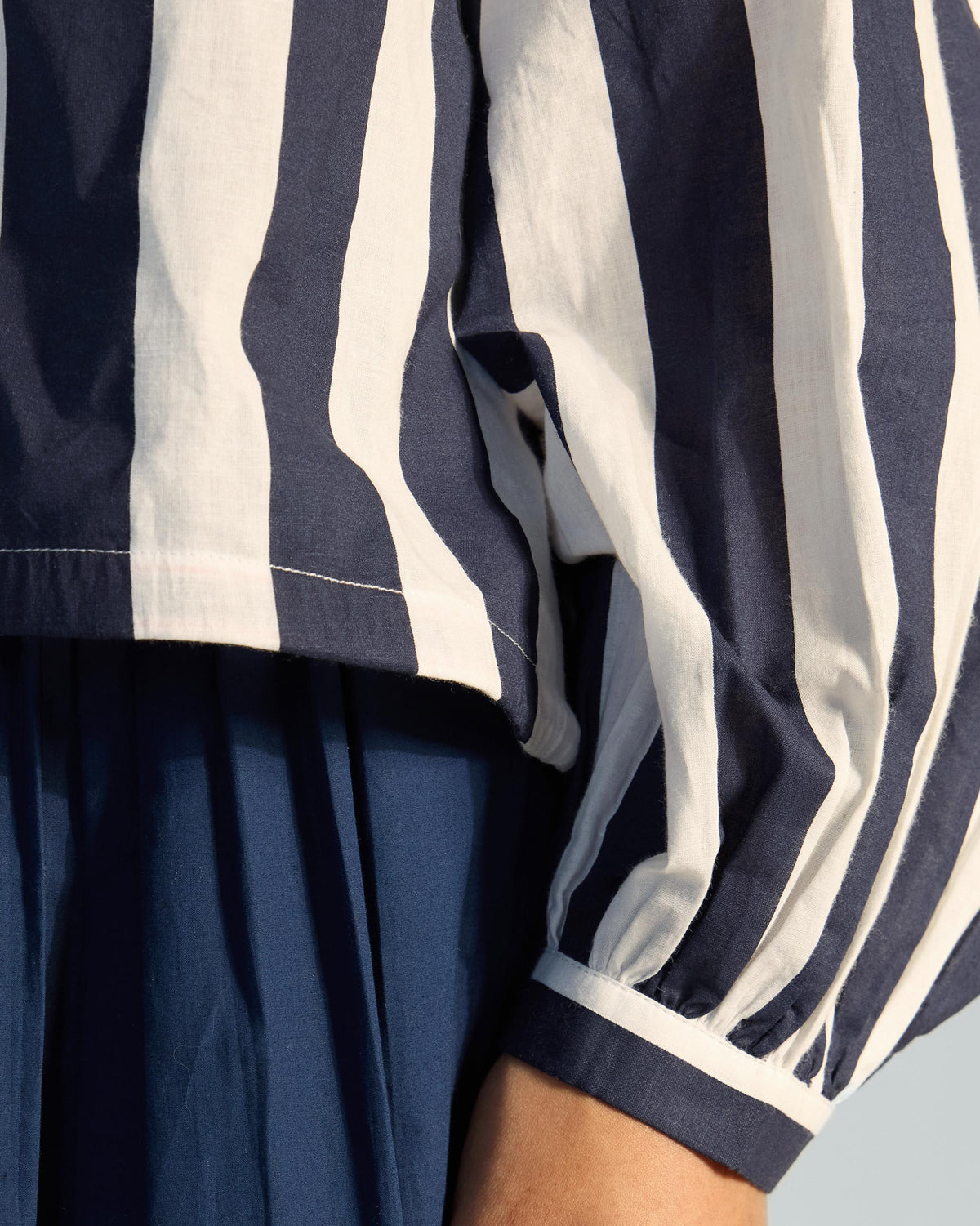 Close-up of a navy cuff on a striped Zaya top sleeve.