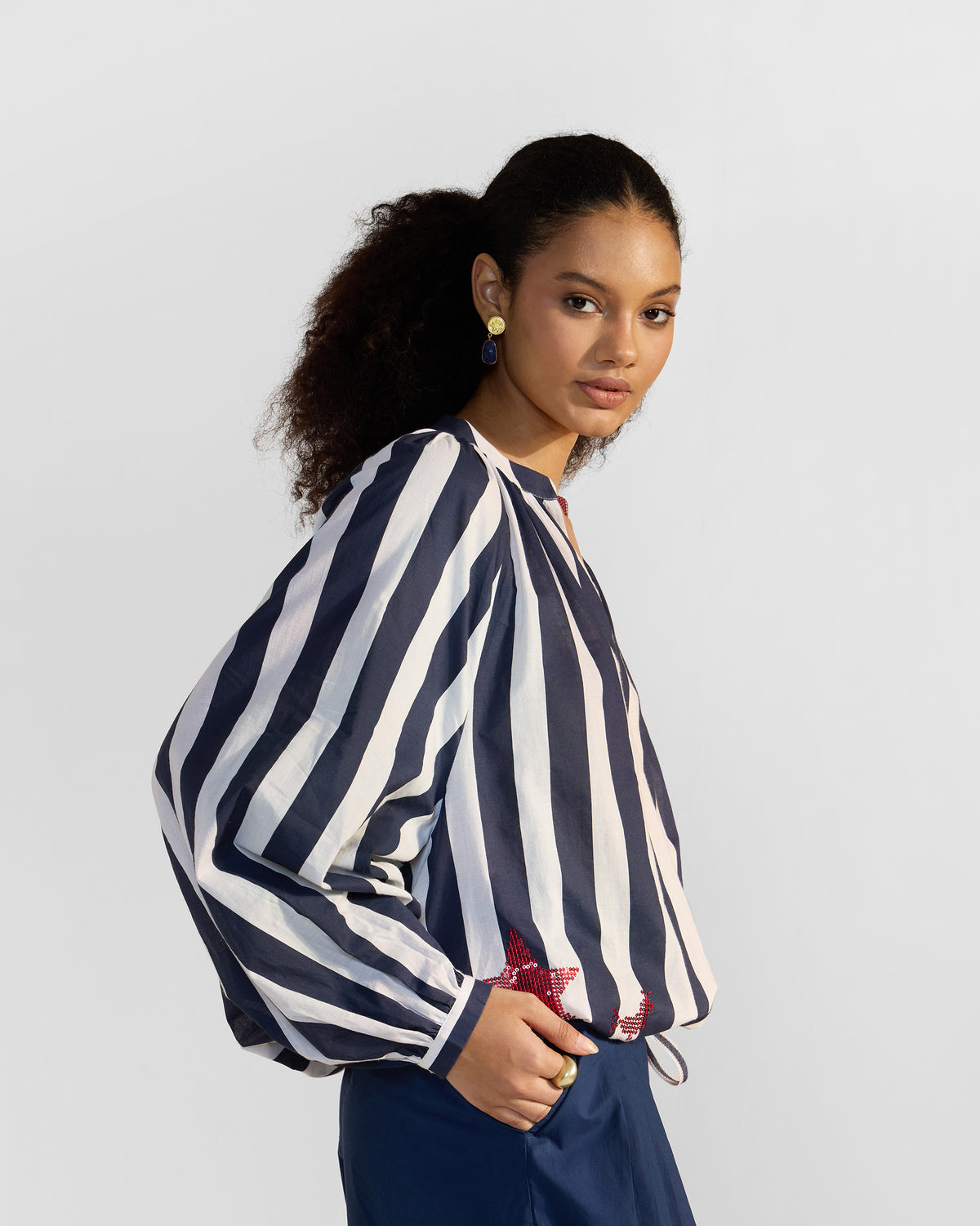 Person wearing a navy and white striped Zaya top with a red star motif.