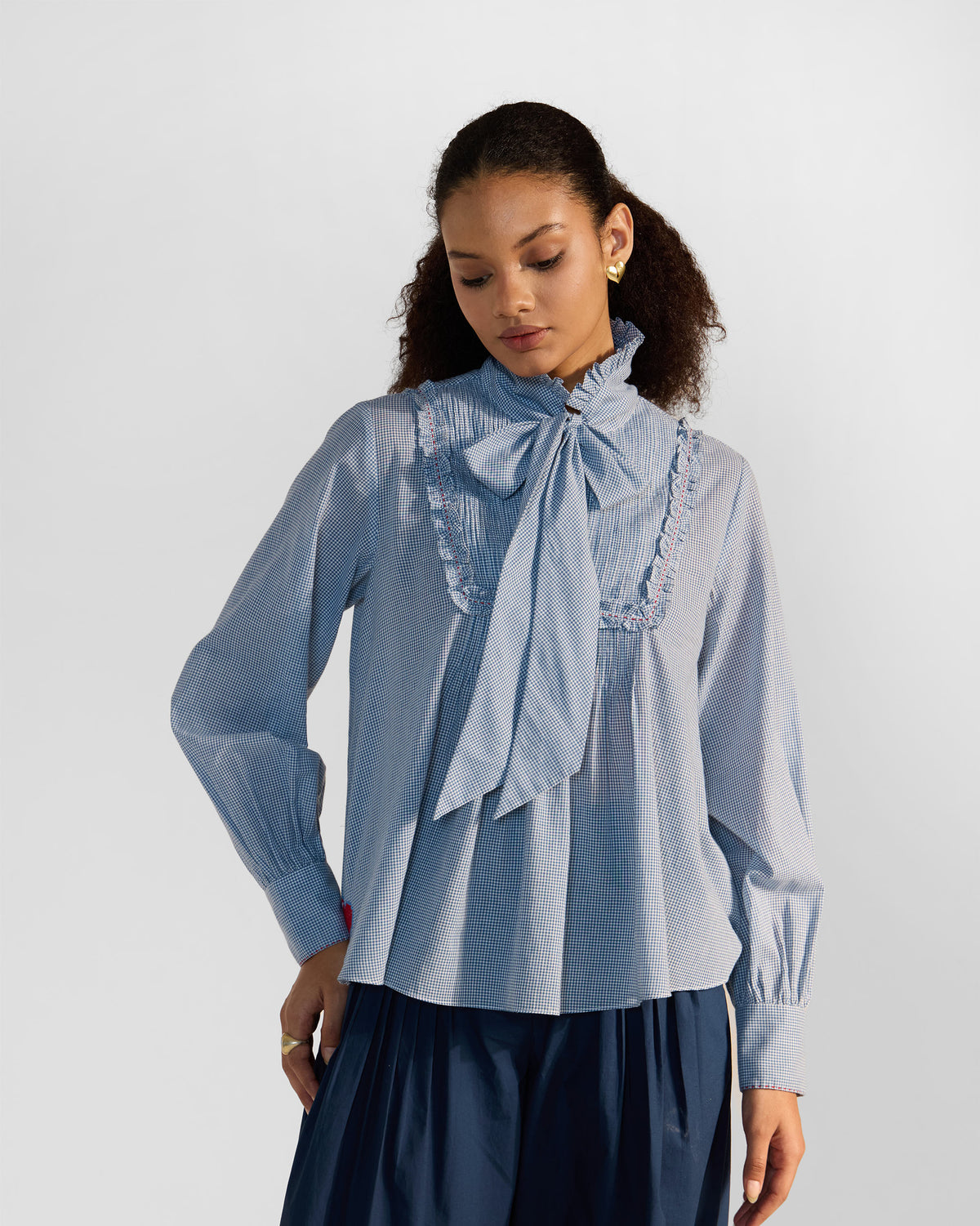 Person wearing a blue check Lona necktie top.