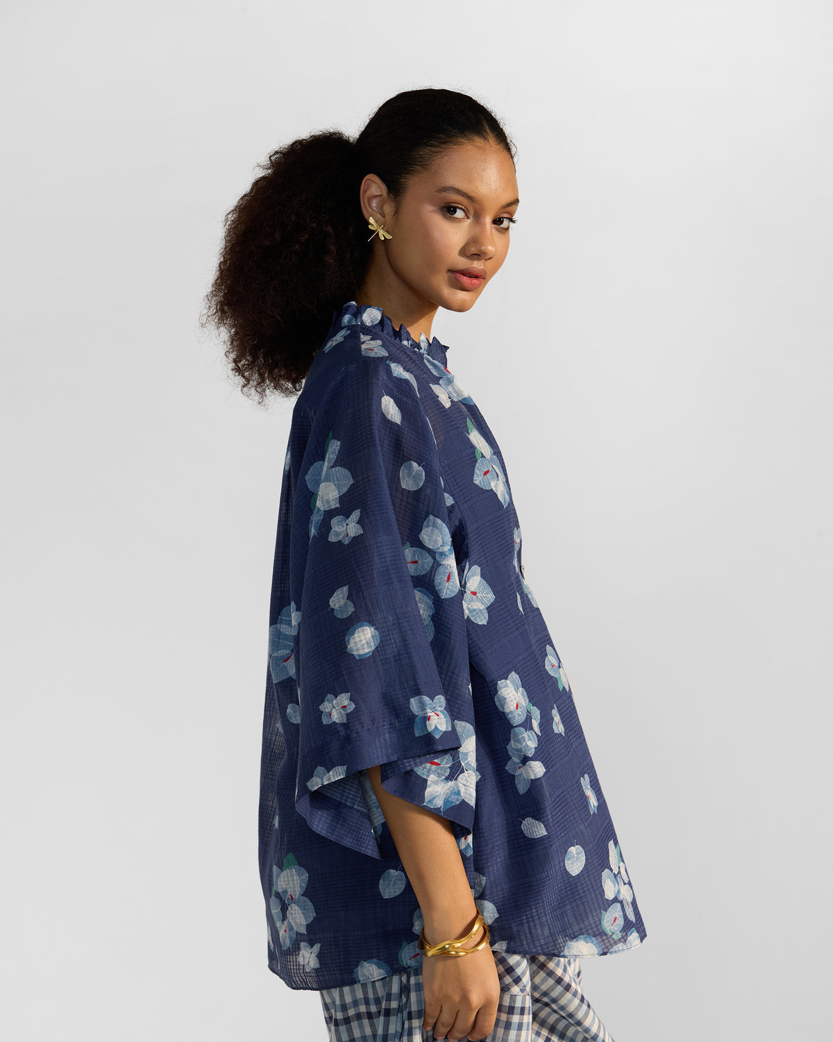 Side view of a navy Lina shirt with slip showing wide sleeves and a ruffled collar.
