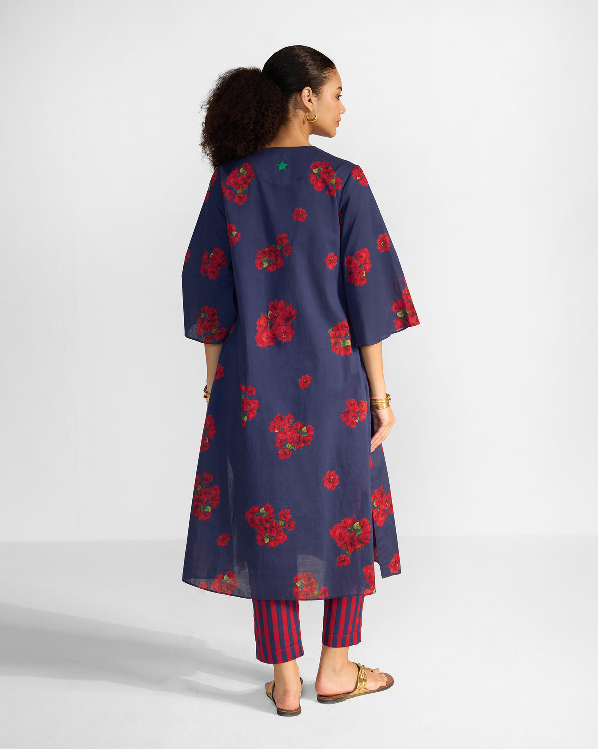 Back of a blue Kaari Kurta with red floral print and a green star.