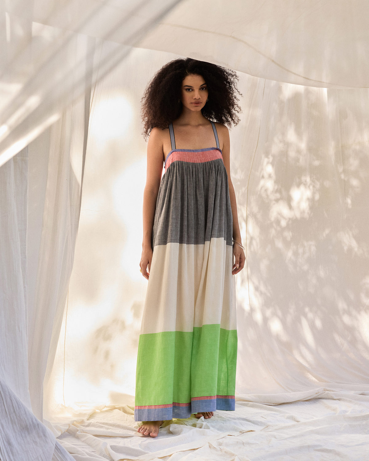 Person wearing a multicolour Bina maxi dress with charcoal, cream, and green tiers.