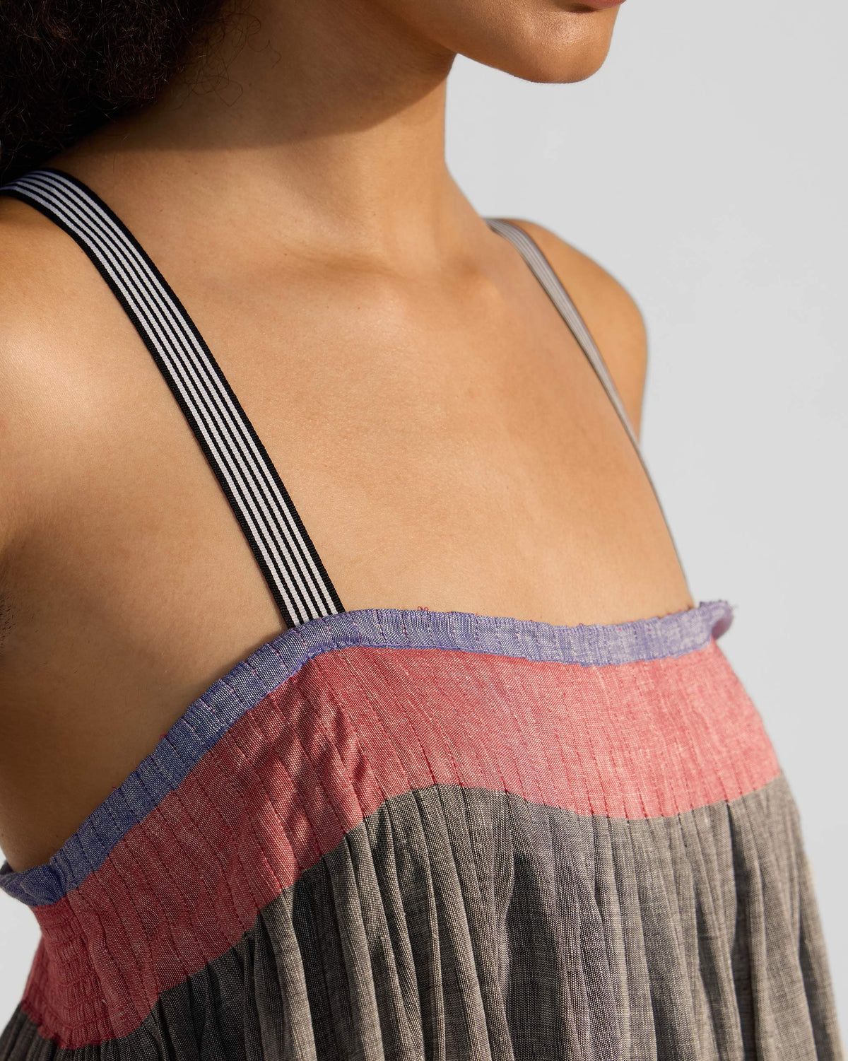 Close-up of the striped strap and pink bodice band on a Bina dress.