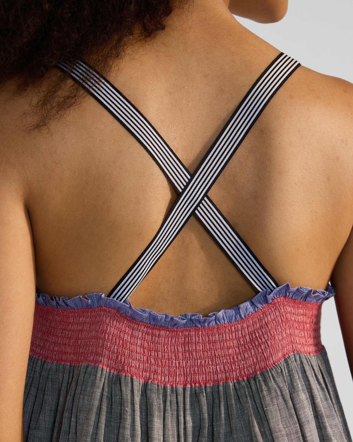 Close-up of crossed striped straps on the back of a Bina dress.