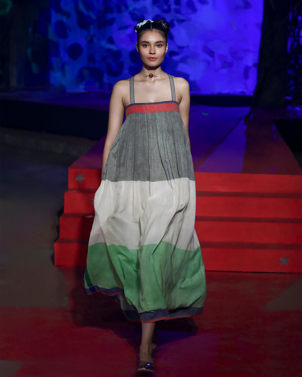 Person wearing a sleeveless multicolour Bina maxi dress with colour-block tiers.
