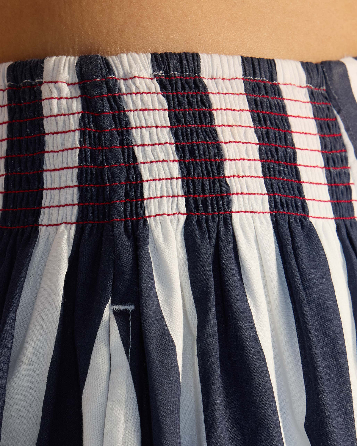 Close-up of the smocked waistband on a navy and white striped Reyat skirt.