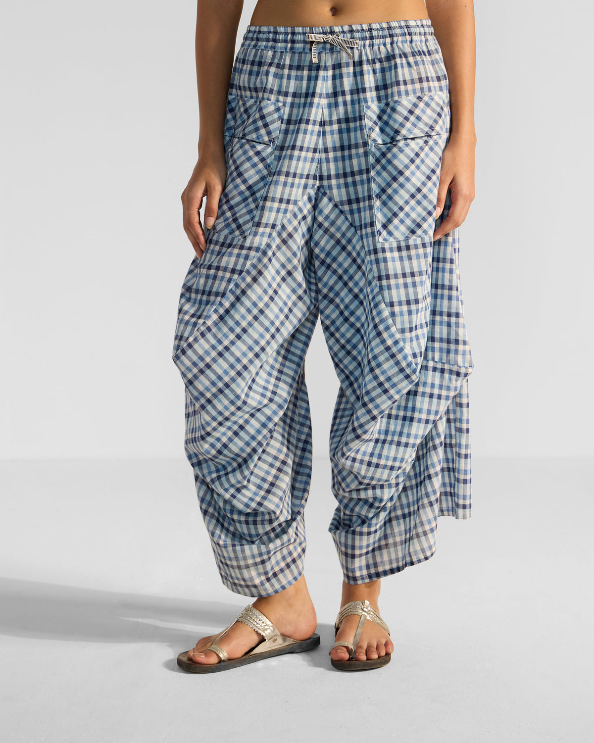 Blue and white checked Yoka trousers with a drawstring waist and large patch pockets.