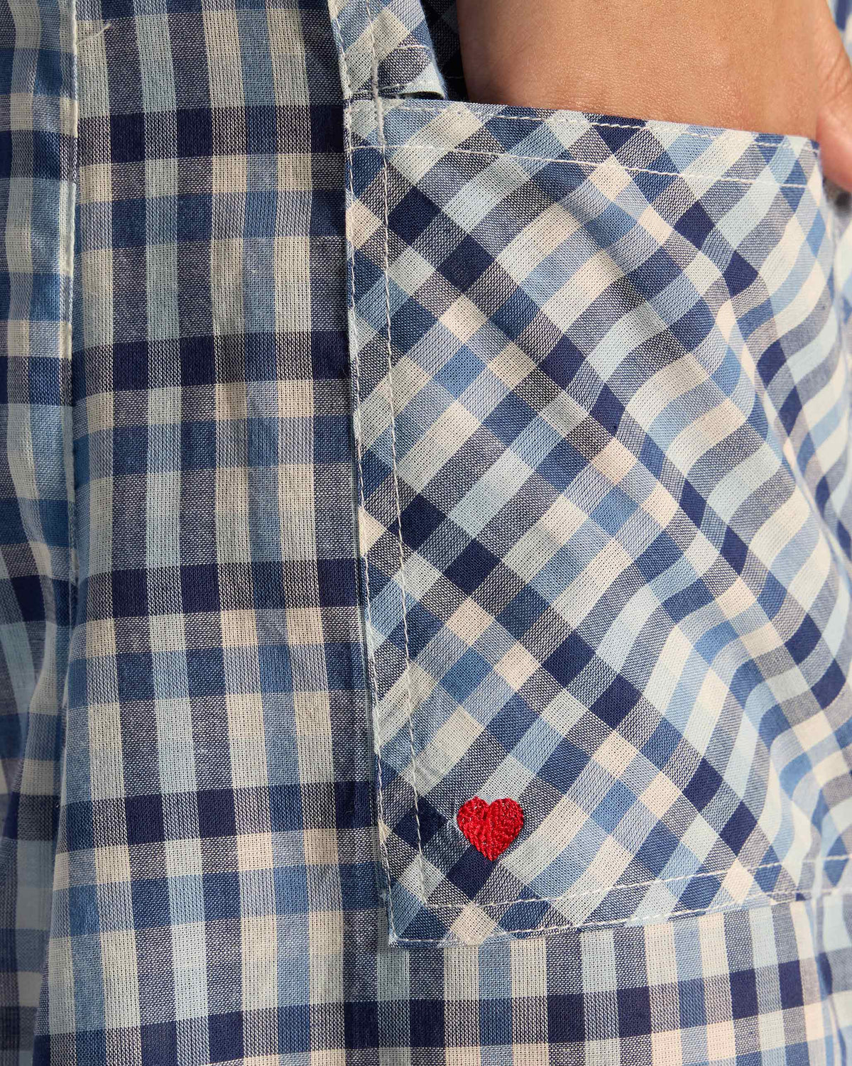 Close-up of the bias check pocket and red heart on blue Yoka trousers.
