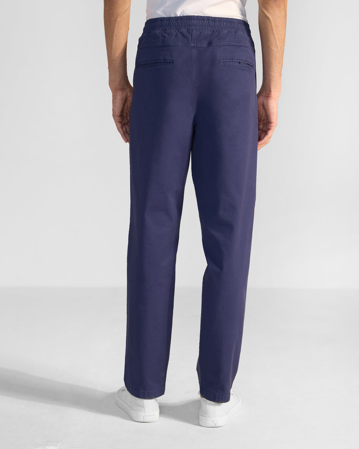 Back of navy Pravah Trousers with an elastic waistband and welt pockets.