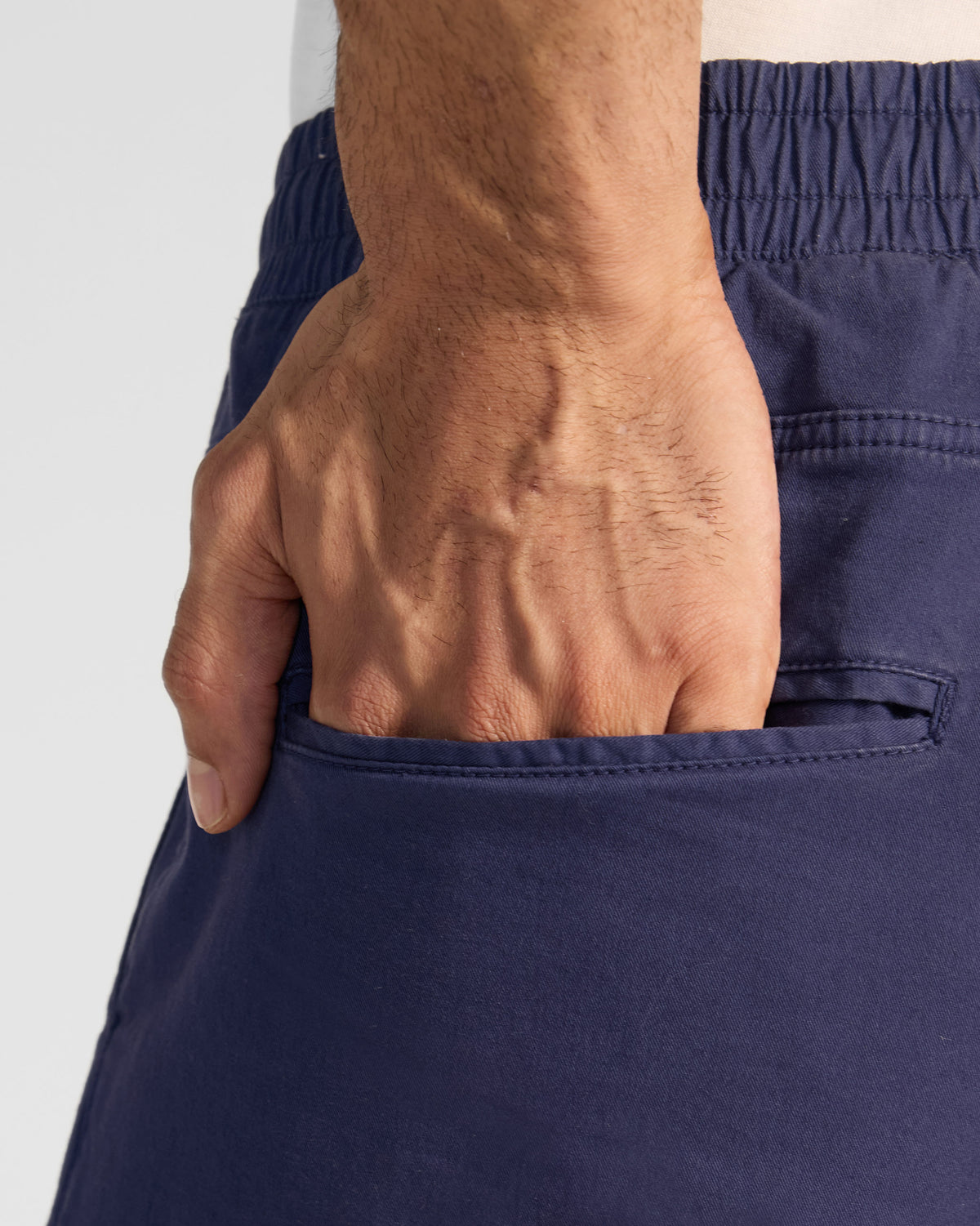 Close-up of a back welt pocket on navy Pravah Trousers.