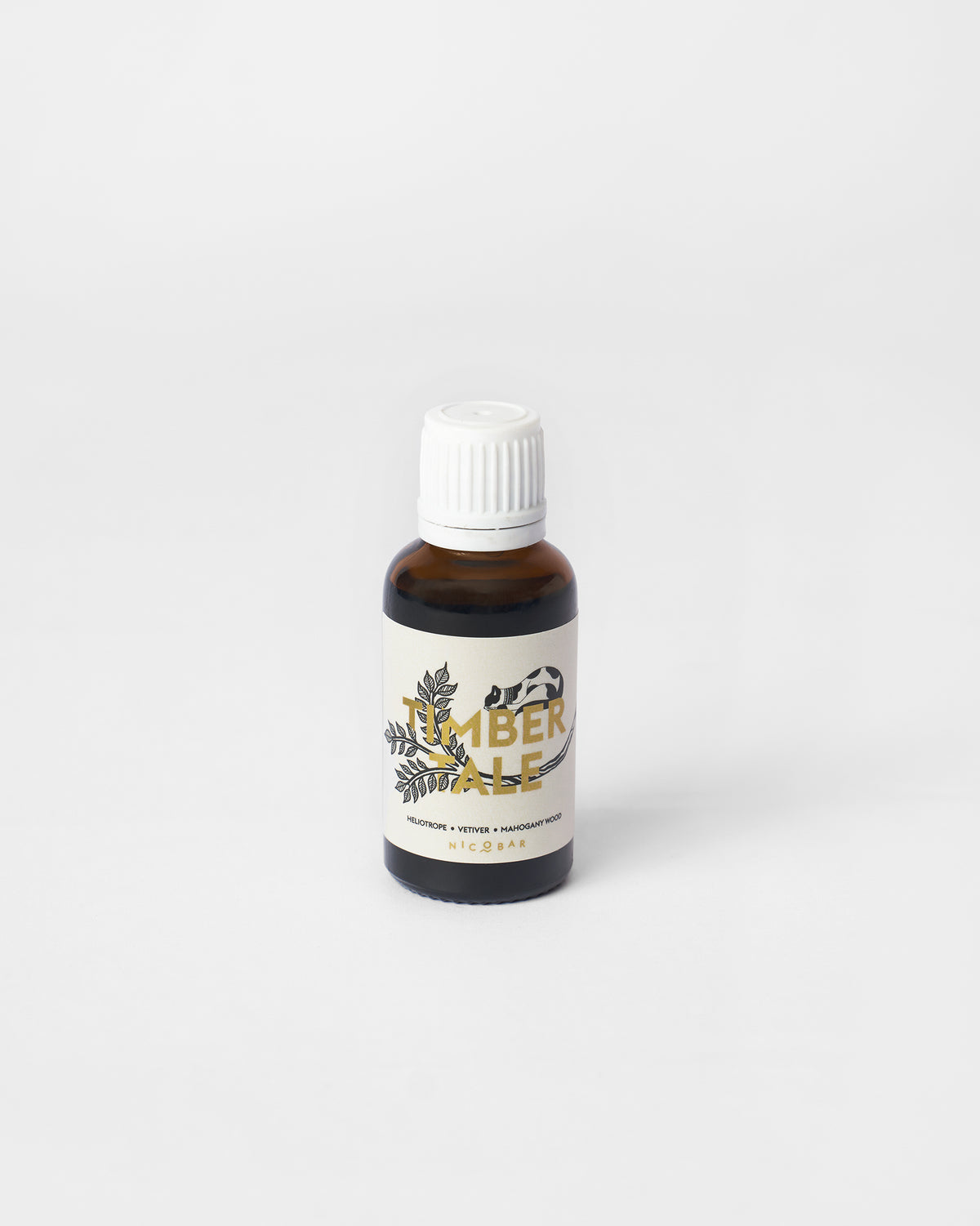 Amber Timbertale oil vial with a cream label listing heliotrope, vetiver and mahogany wood.