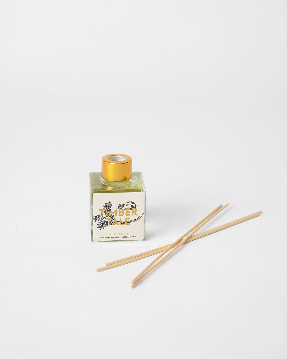 Timbertale Reed Diffuser with a gold cap and reeds lying beside it.