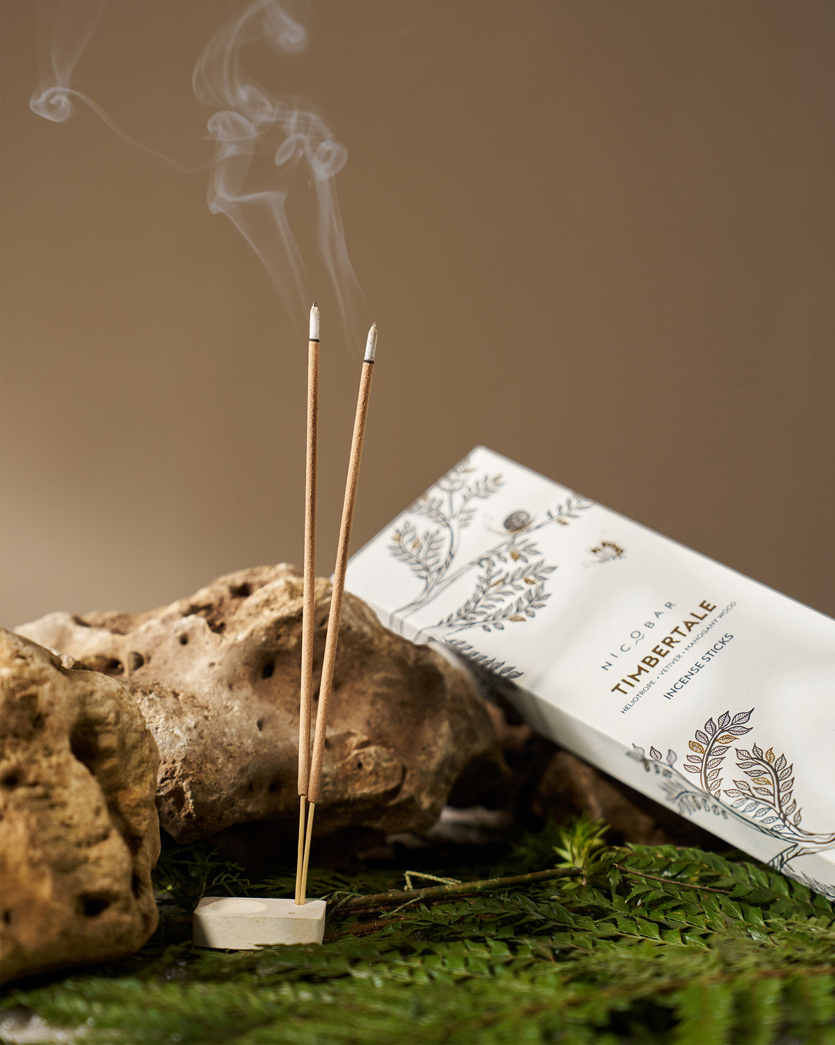 Timbertale Incense Sticks burning in a stone holder beside the box.