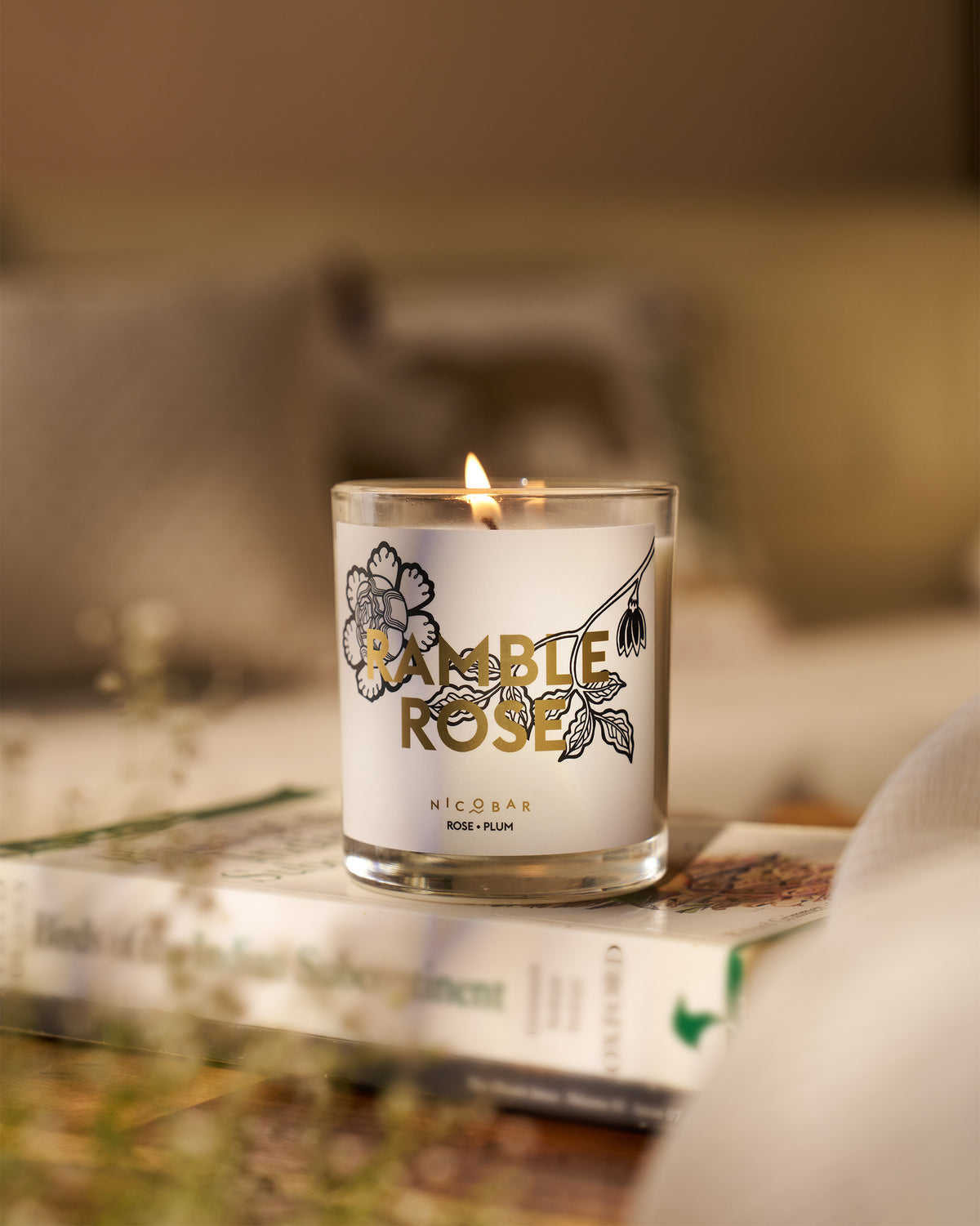 Lit Ramblerose Candle in a clear glass.