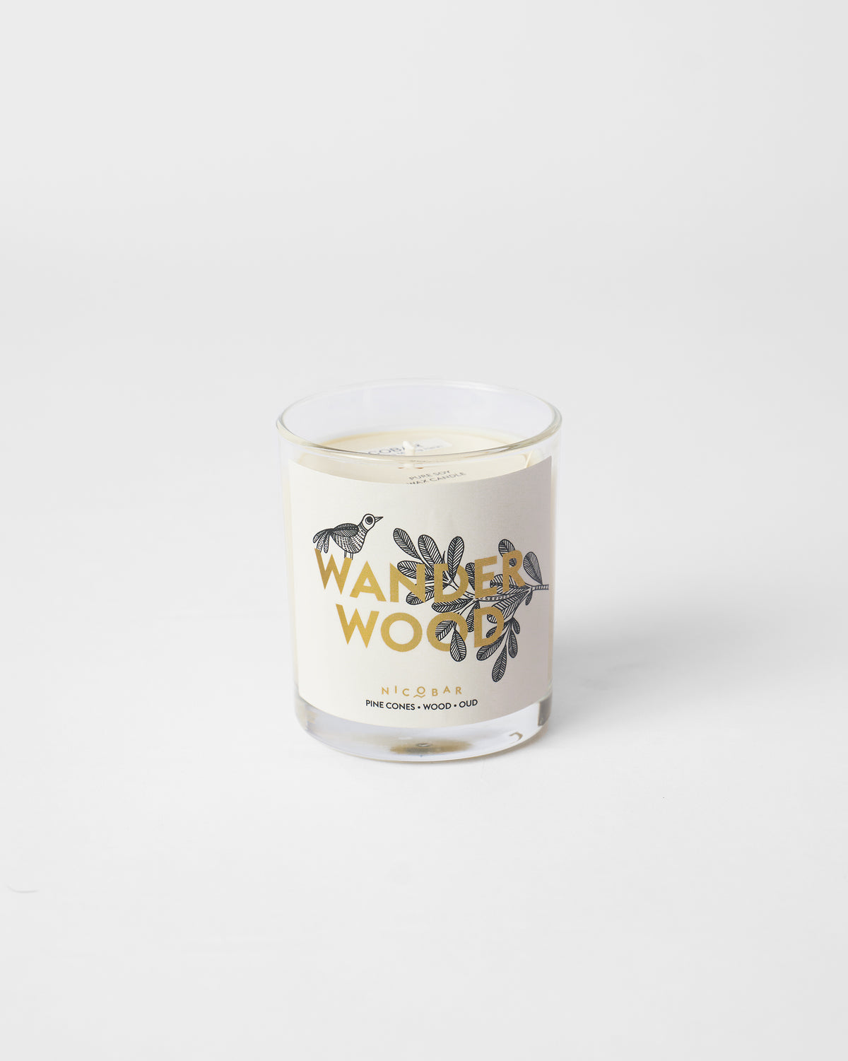 Wanderwood glass candle labeled with pine cones, wood and oud.