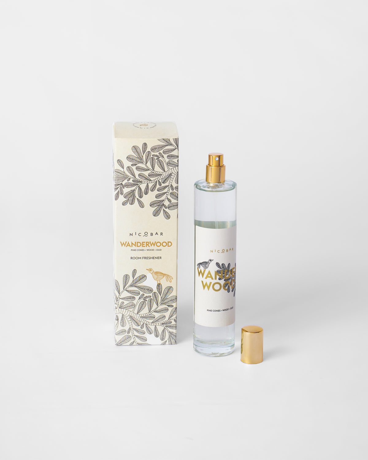 Wanderwood Room Spray bottle with its gold cap off, beside its box.