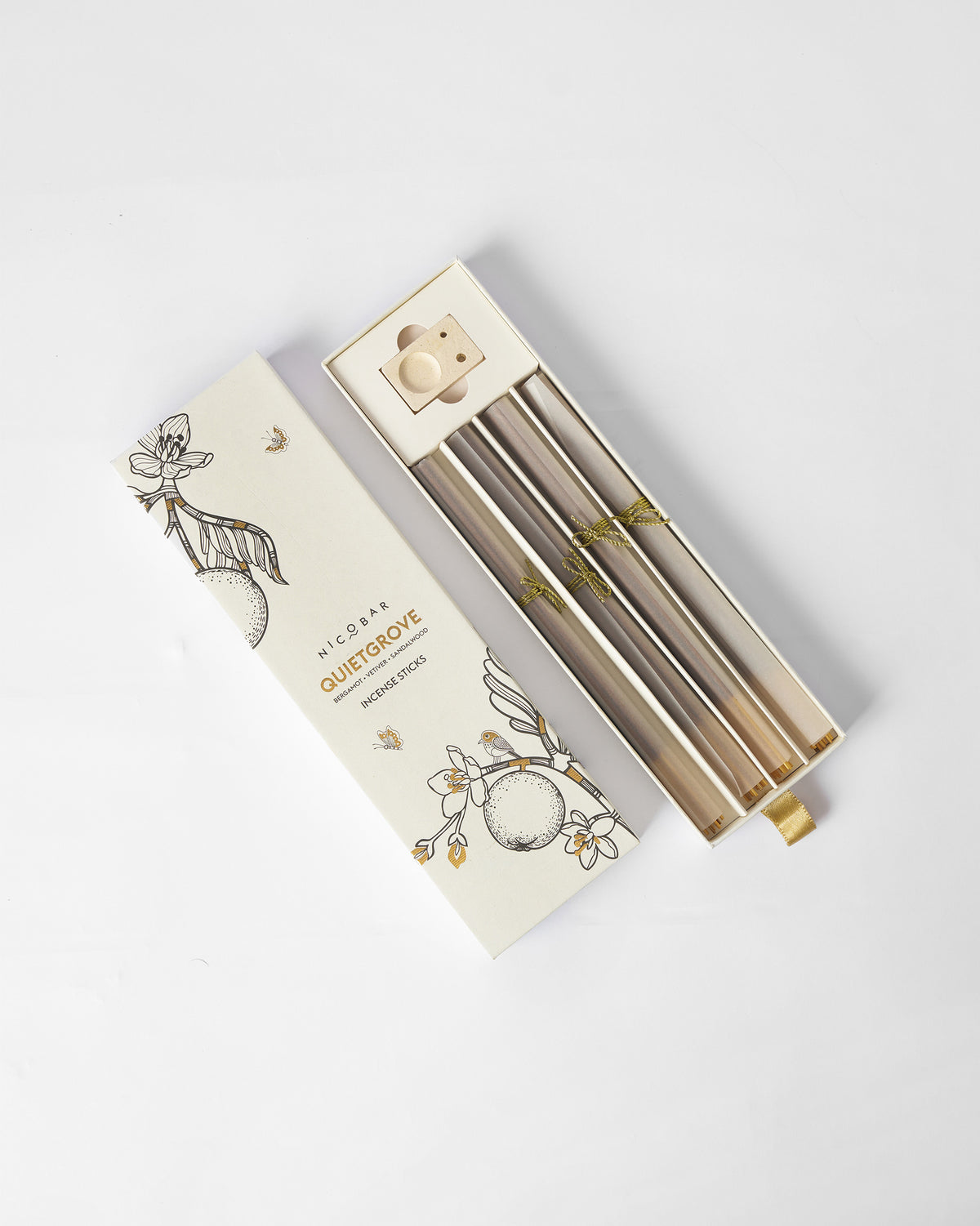 Quiet Grove Incense Sticks in an open box, with gold motifs on the sticks.