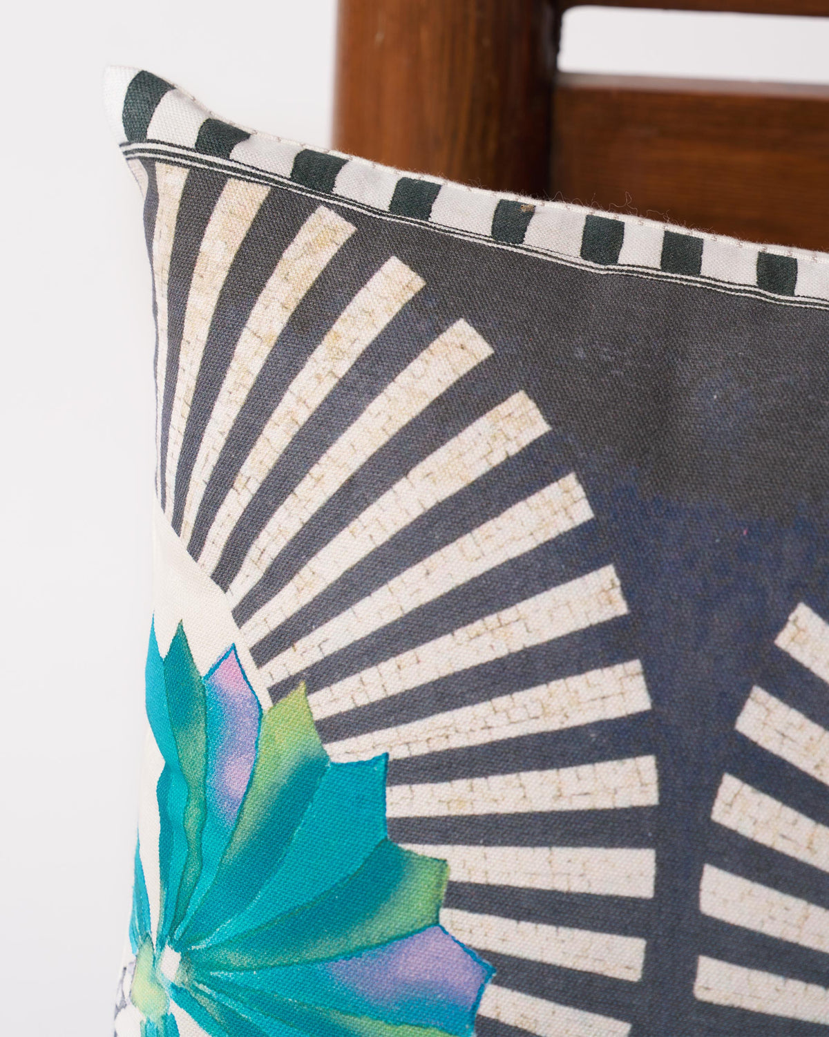 Close-up of the Swaying Palm Cushion Cover showing its striped piped edge and a teal frond.