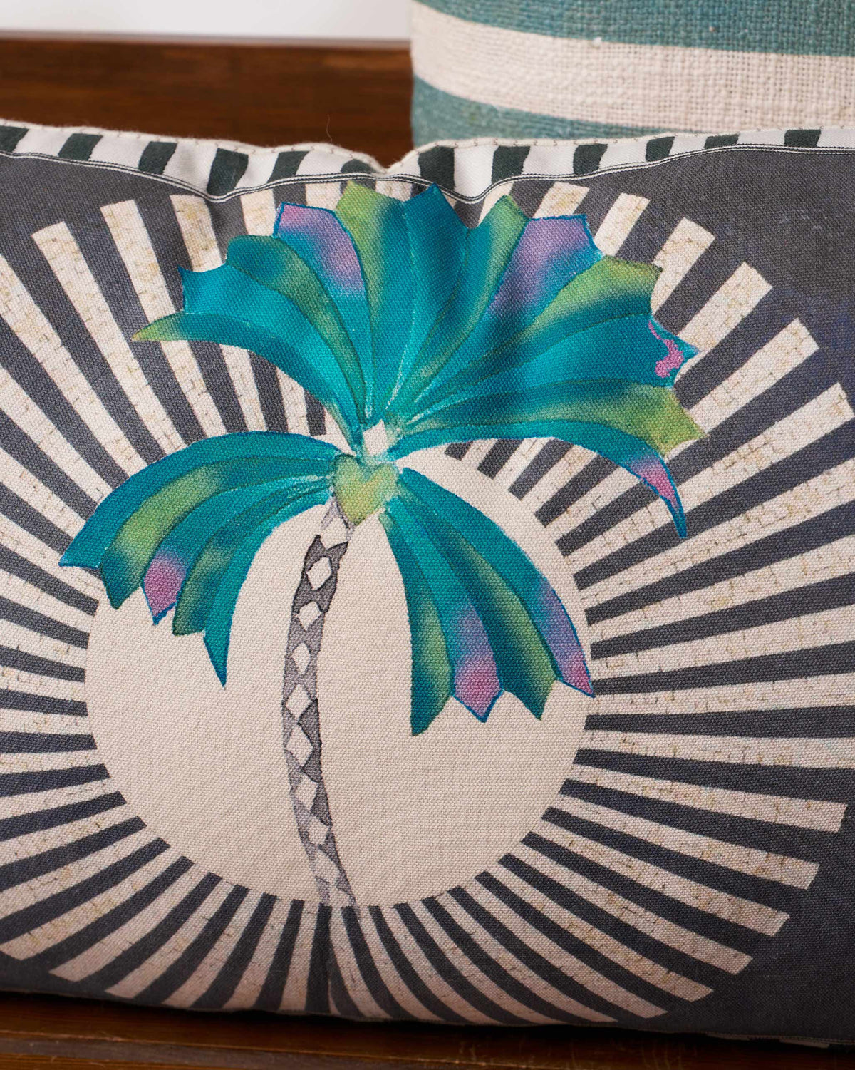 Close-up of the Swaying Palm Cushion Cover showing a teal palm with a patterned trunk.
