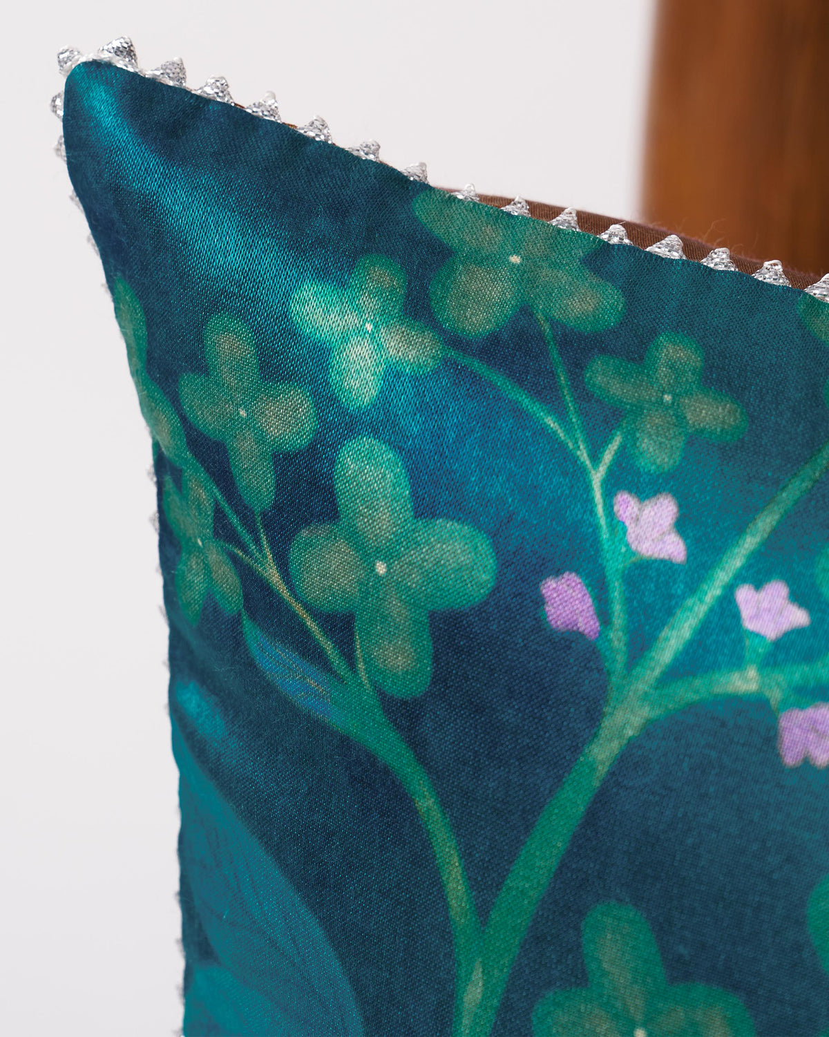Close-up of Fern Cushion Cover showing green flowers, pink blooms and a beaded edge.