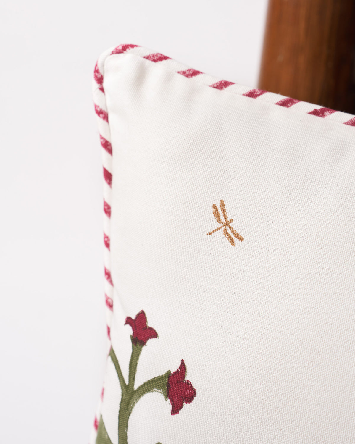 Close-up of red-and-white Kandy piping on a Blooming Mogra cushion cover.