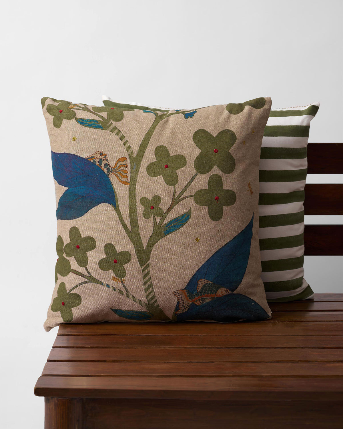 Fern Bloom cushion cover with green flowers and blue leaves.