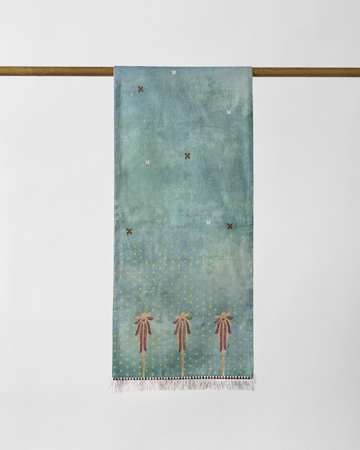 Yamuna table runner in teal with gold dots and three tall motifs.