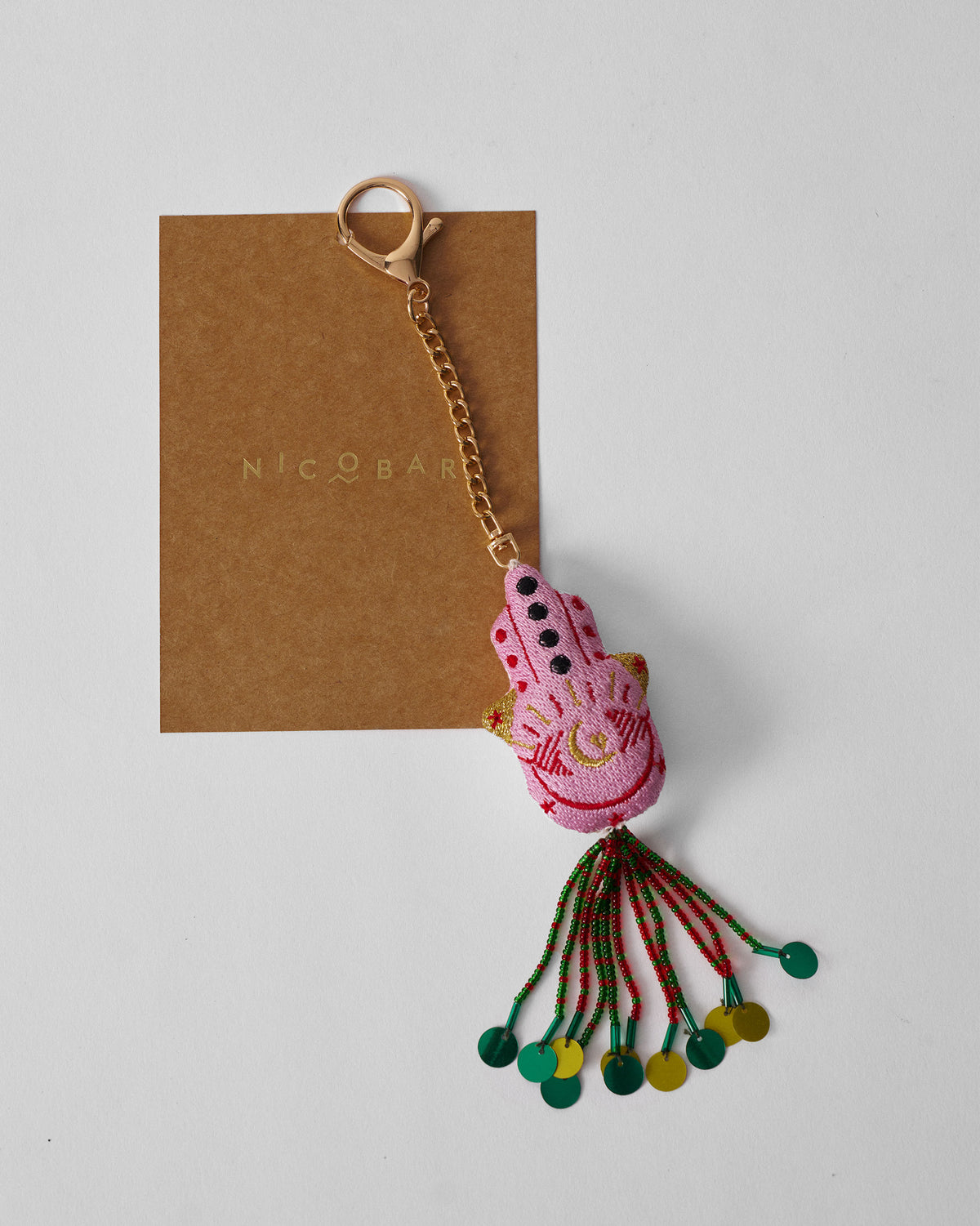 Hamsa Charm in pink with gold accents and a beaded tassel.
