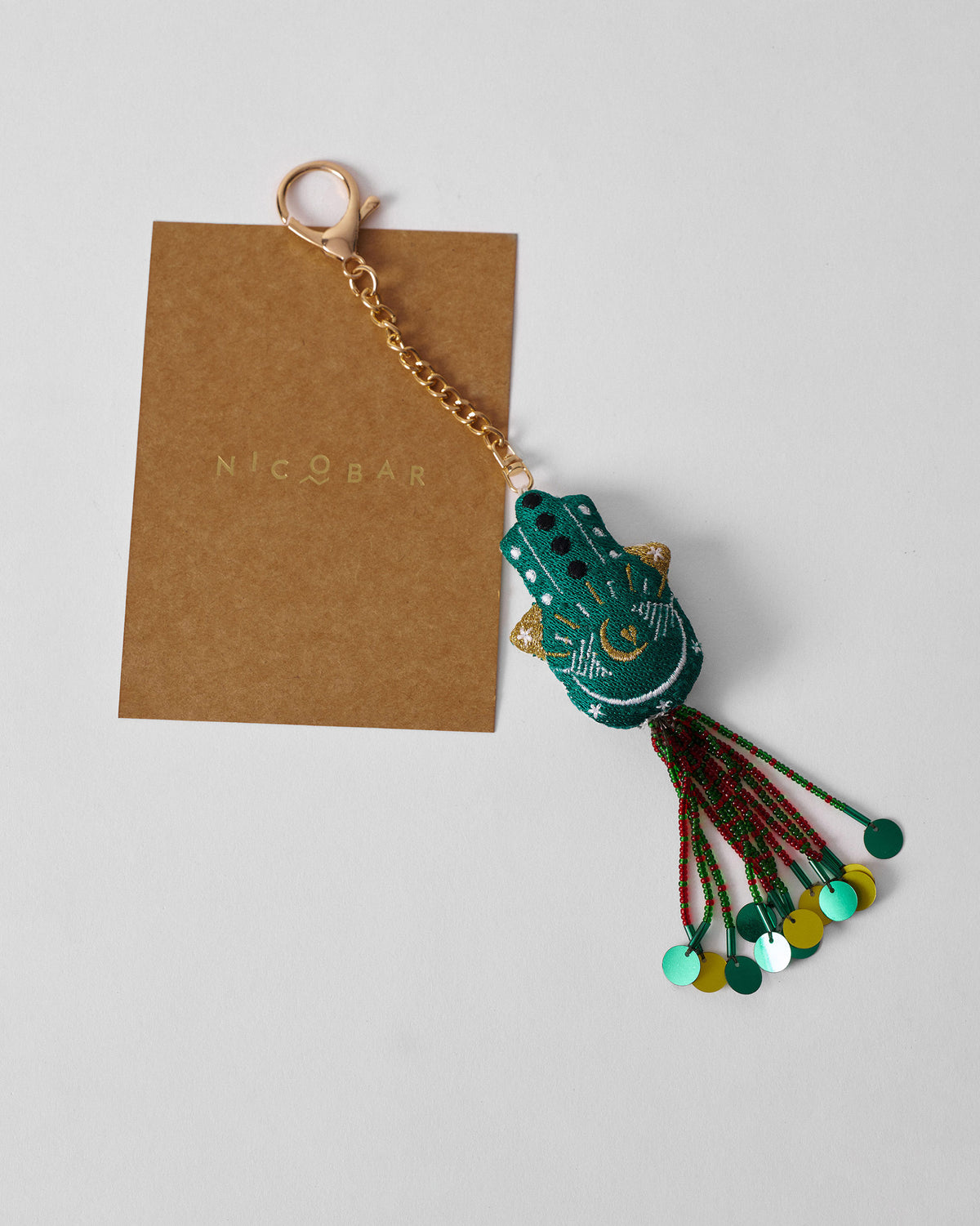 Hamsa Charm in green with gold accents and a beaded tassel.