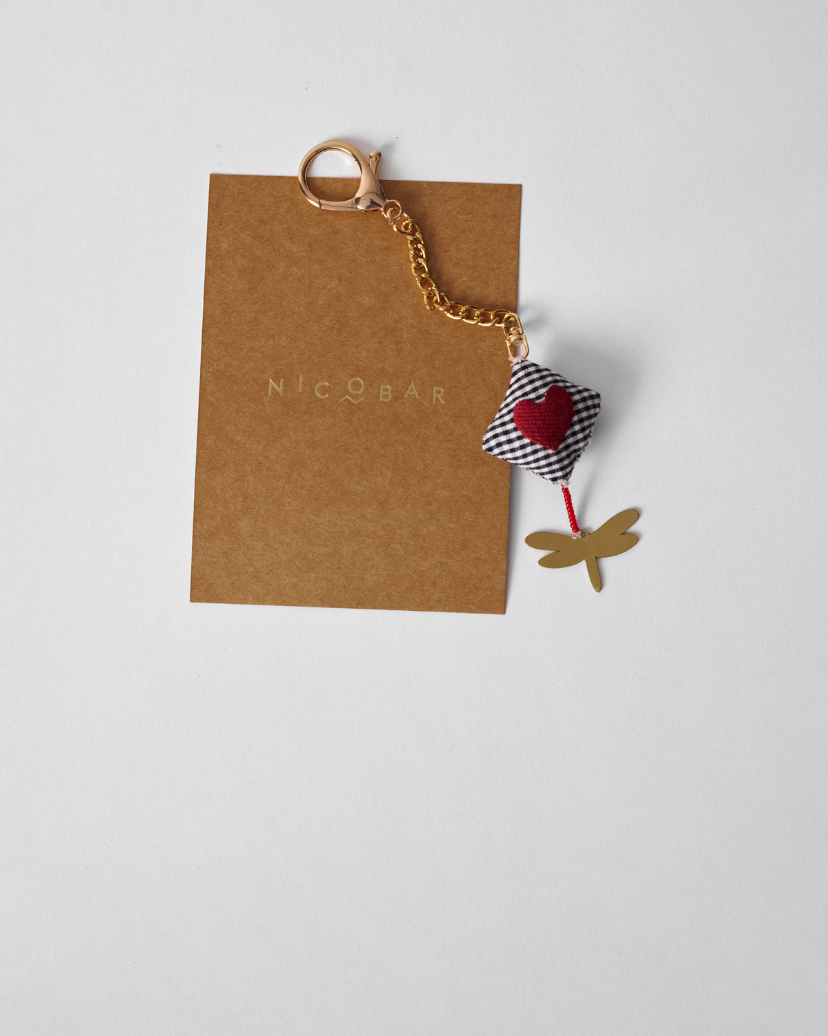 Dragonfly Charm hanging from a gold keychain with a gingham heart.