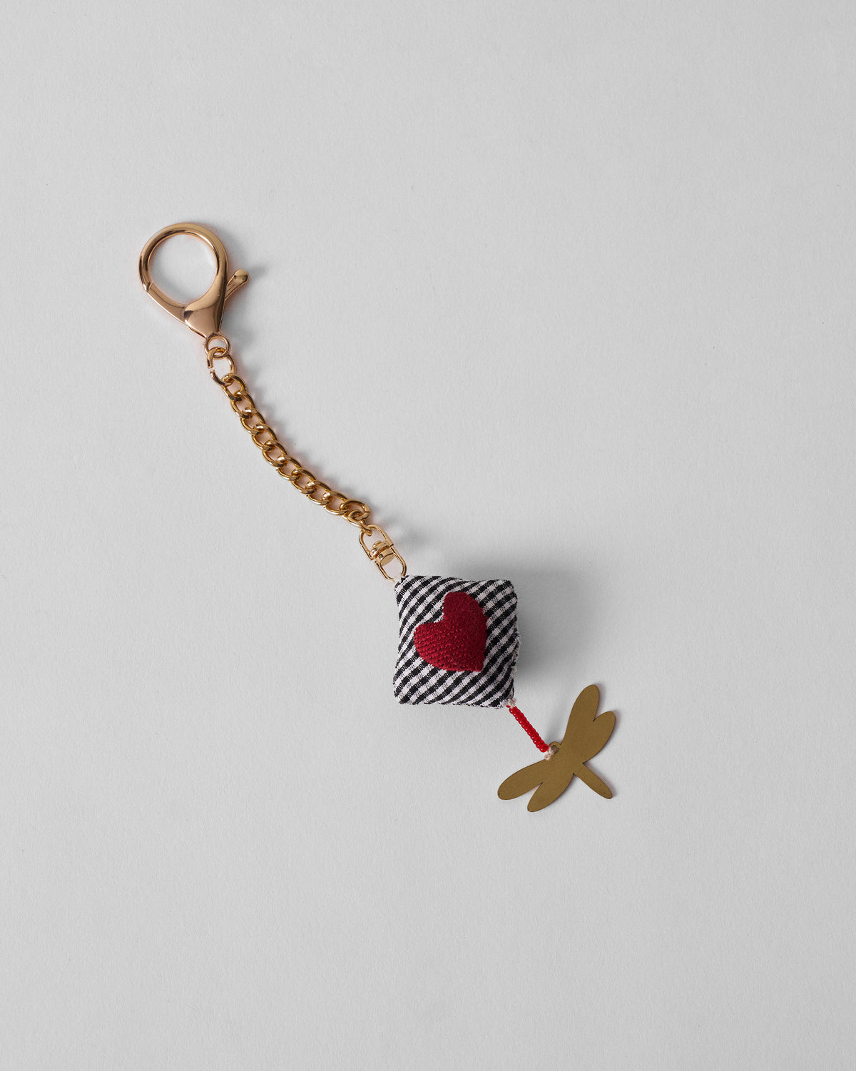 Dragonfly Charm with a gingham heart on a gold chain and clasp.