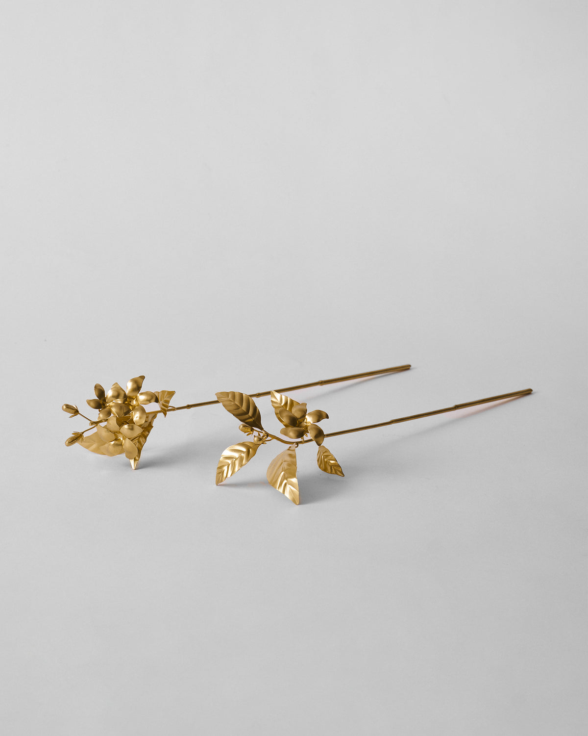 Pair of gold Mogra stems with jasmine-like flowers and leaves.