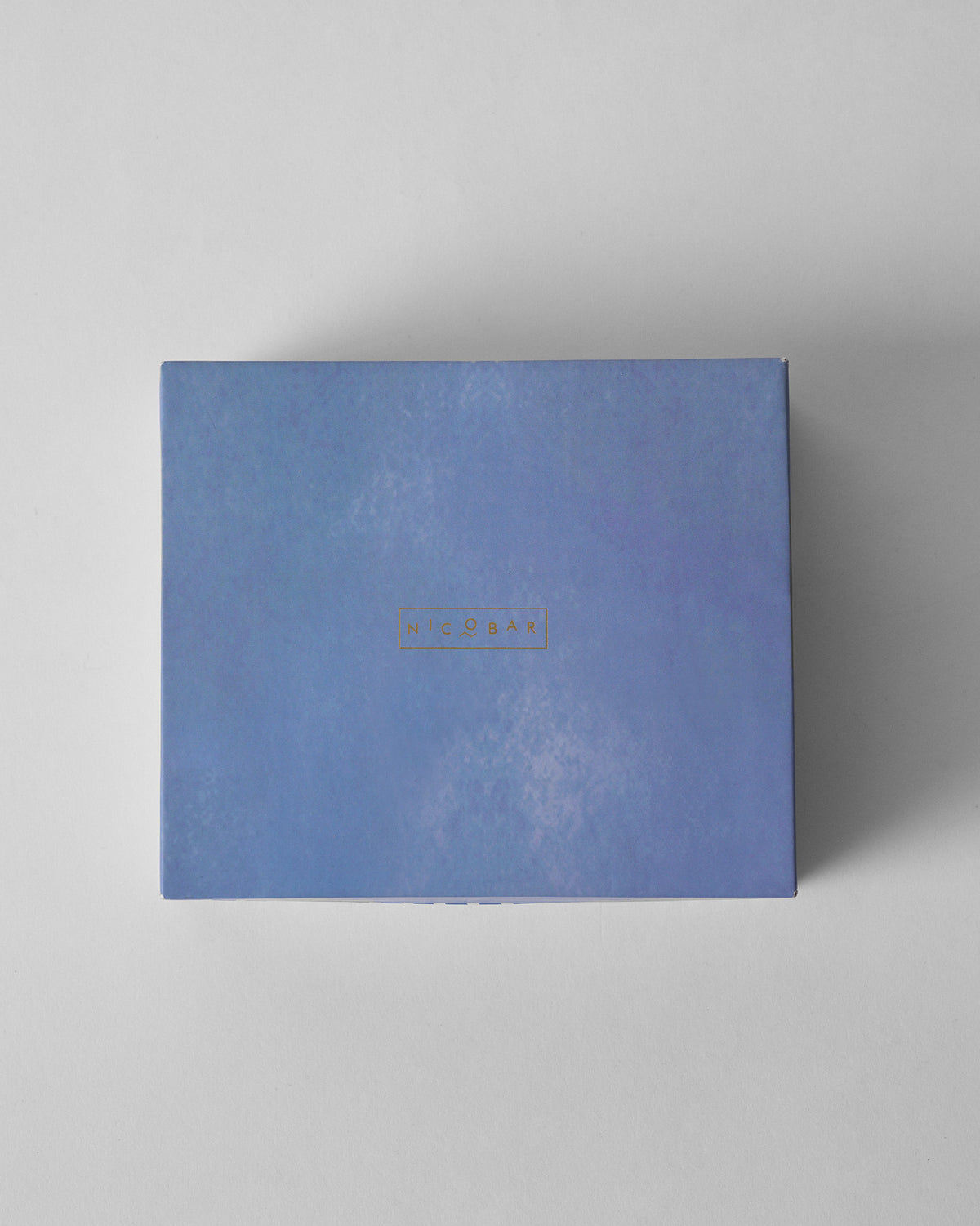Closed periwinkle Nicobar gift box for the turtle keychain and paperweight set.