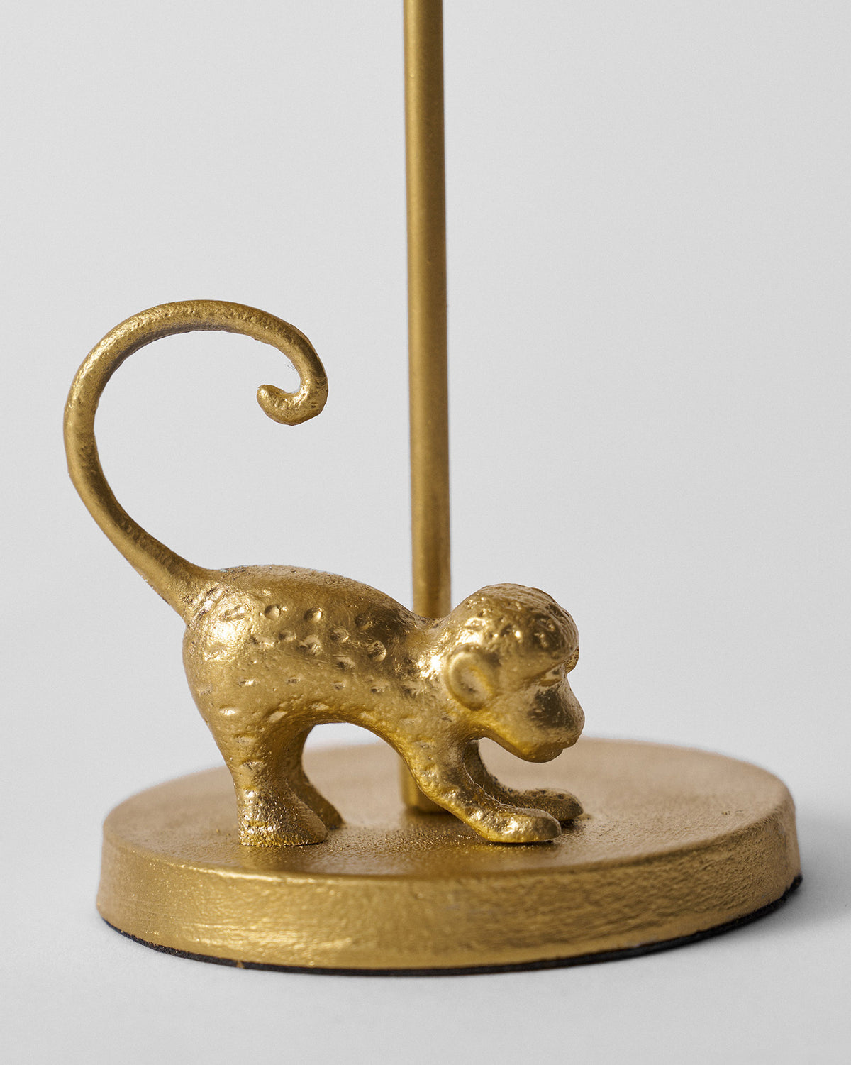 Close-up of the gold monkey figurine at the base of the Palm Bloom candle holder.