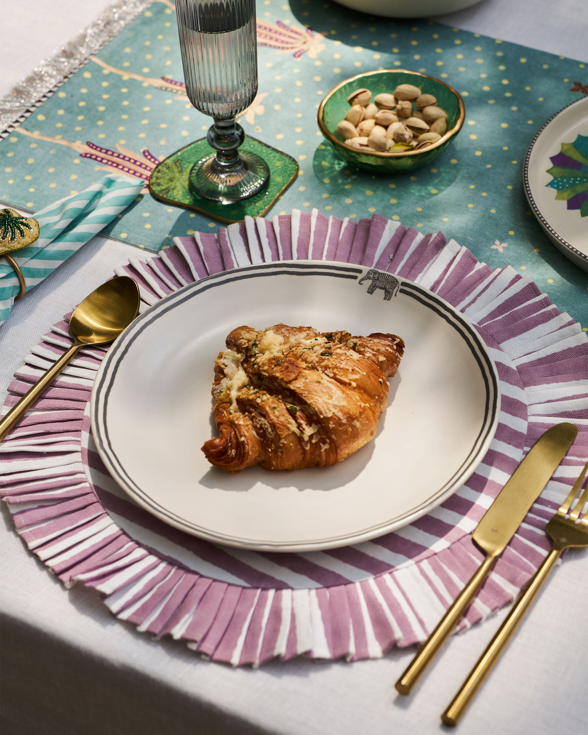 Tusk Dinner Plate with a small elephant motif on the rim, set for a meal.