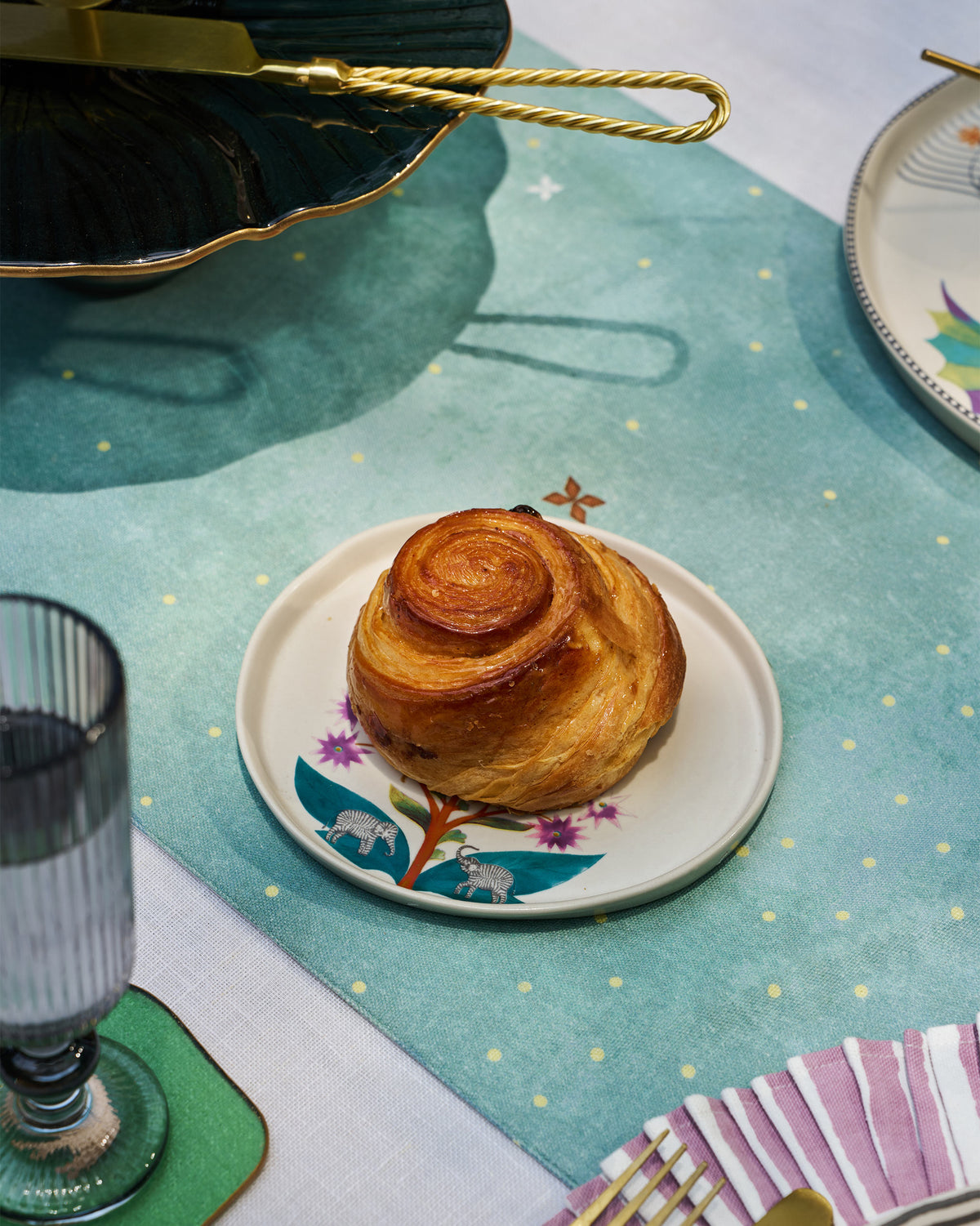 Pastry served on a Mogra Dessert Plate with teal leaves and flowers.