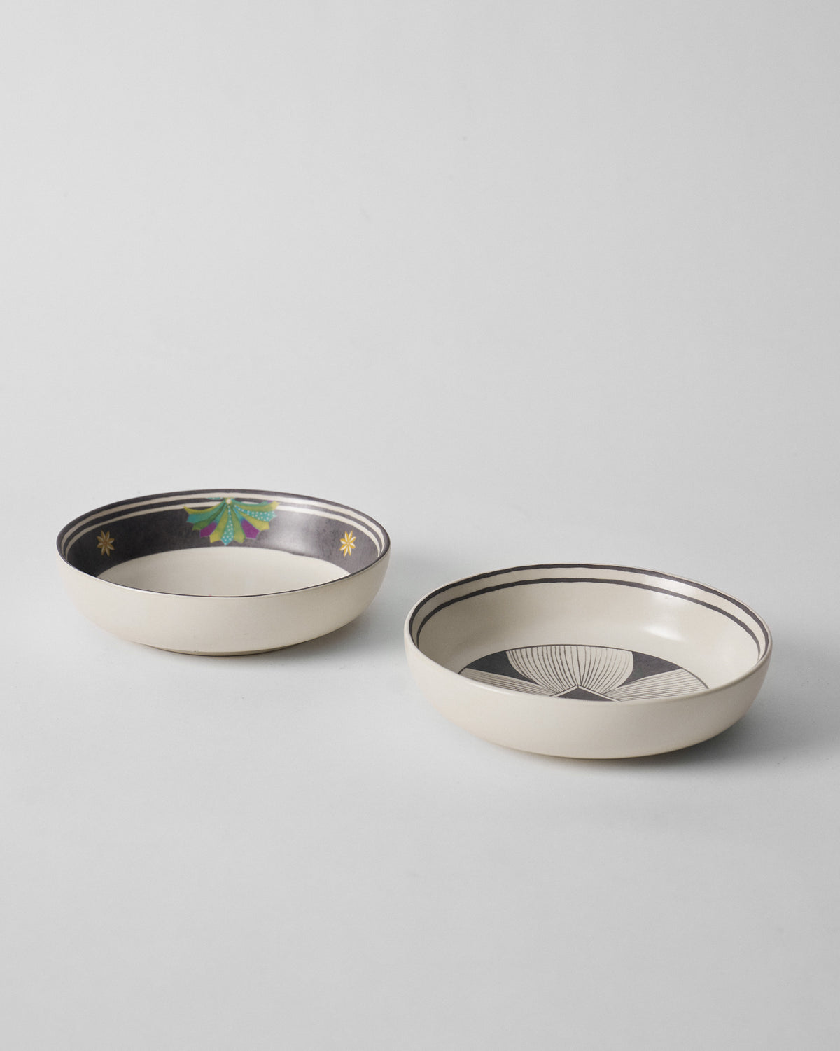 Pair of Palm Bloom shallow bowls with charcoal rim and sunburst designs.