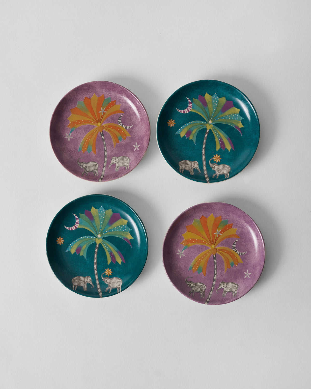 Set of four Palm Bloom tea plates in teal and purple with palm print.