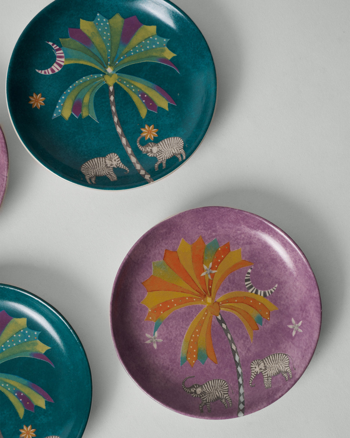 Purple Palm Bloom tea plate with colourful palm and elephant motif.