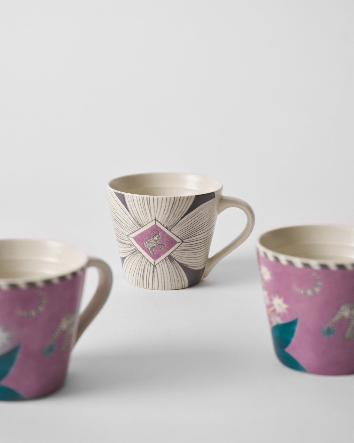 Close-up of a cream Mogra Bloom espresso mug with a charcoal floral pattern and magenta diamond.