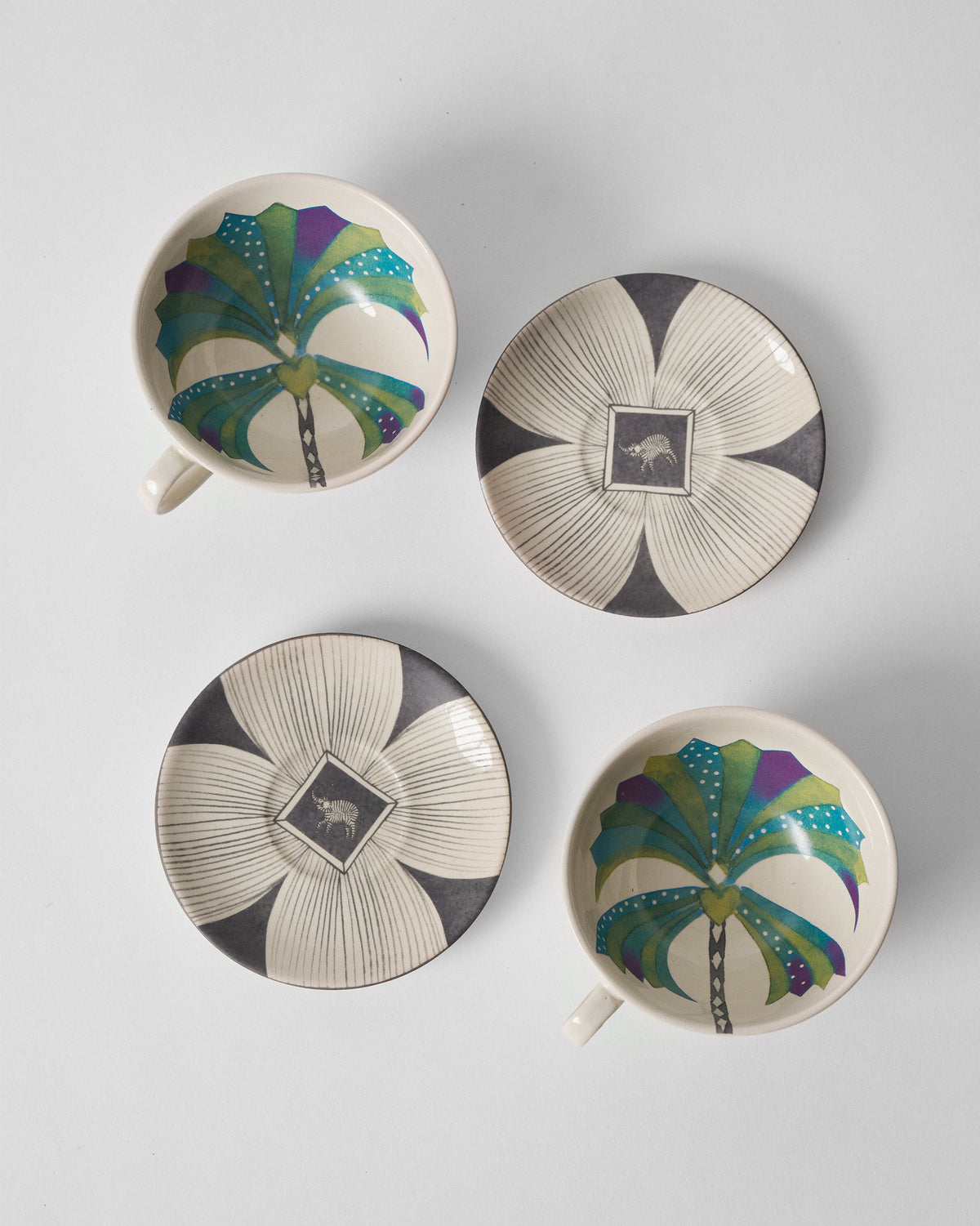 Palm Bloom cups and saucers laid out showing palm interiors and graphic saucers.