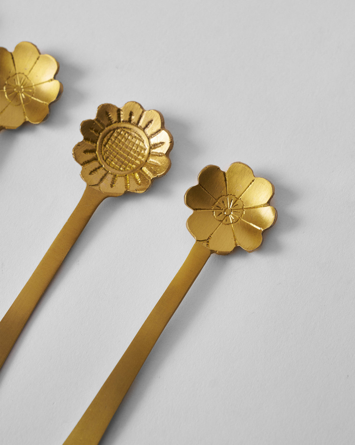 Close-up of Phool coffee spoon flower heads in matte gold brass.