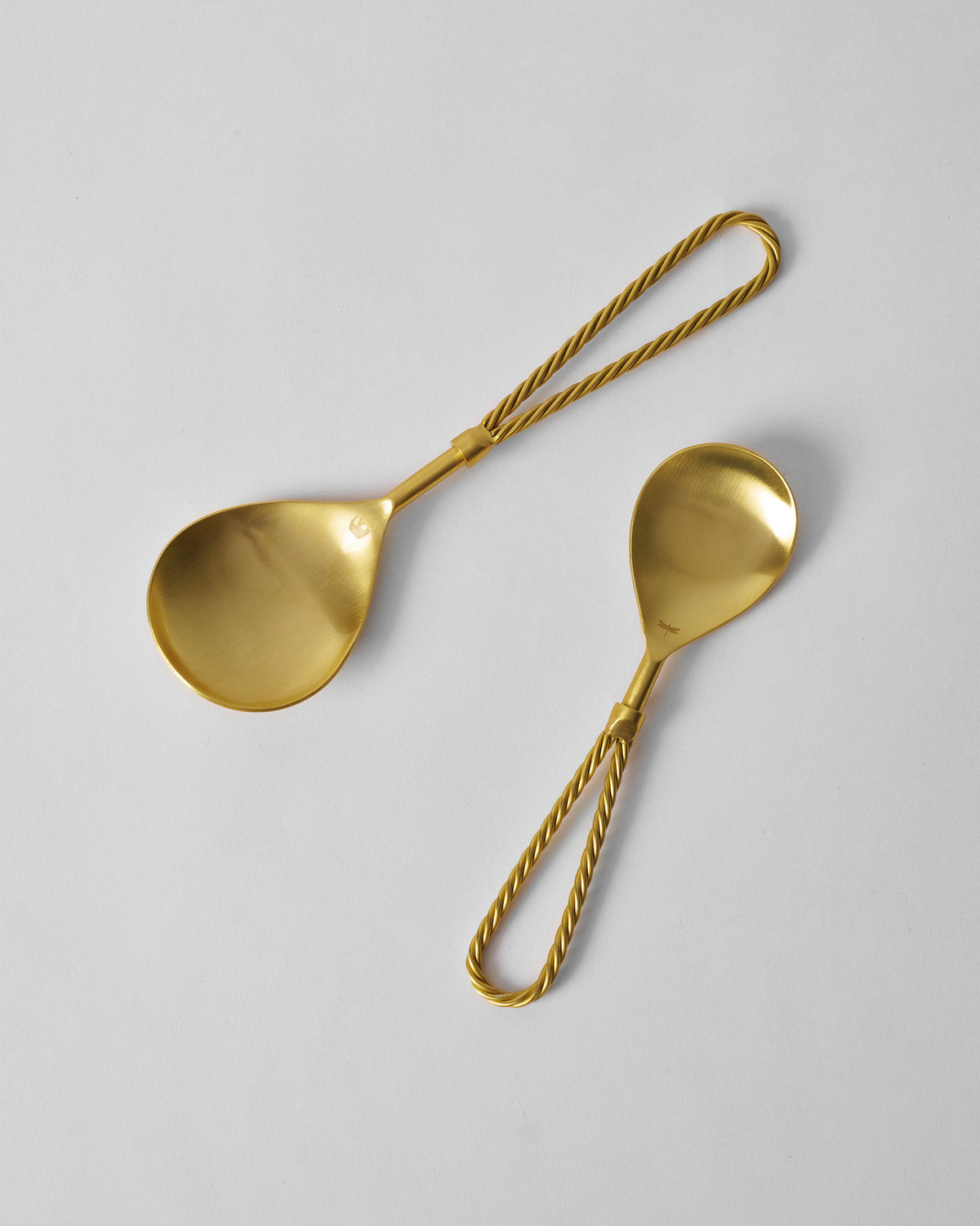 Tusk serving spoons showing twisted handles and shallow bowls.