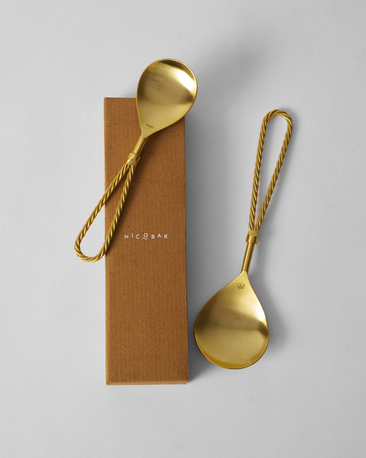 Tusk serving spoons beside a kraft Nicobar gift box.